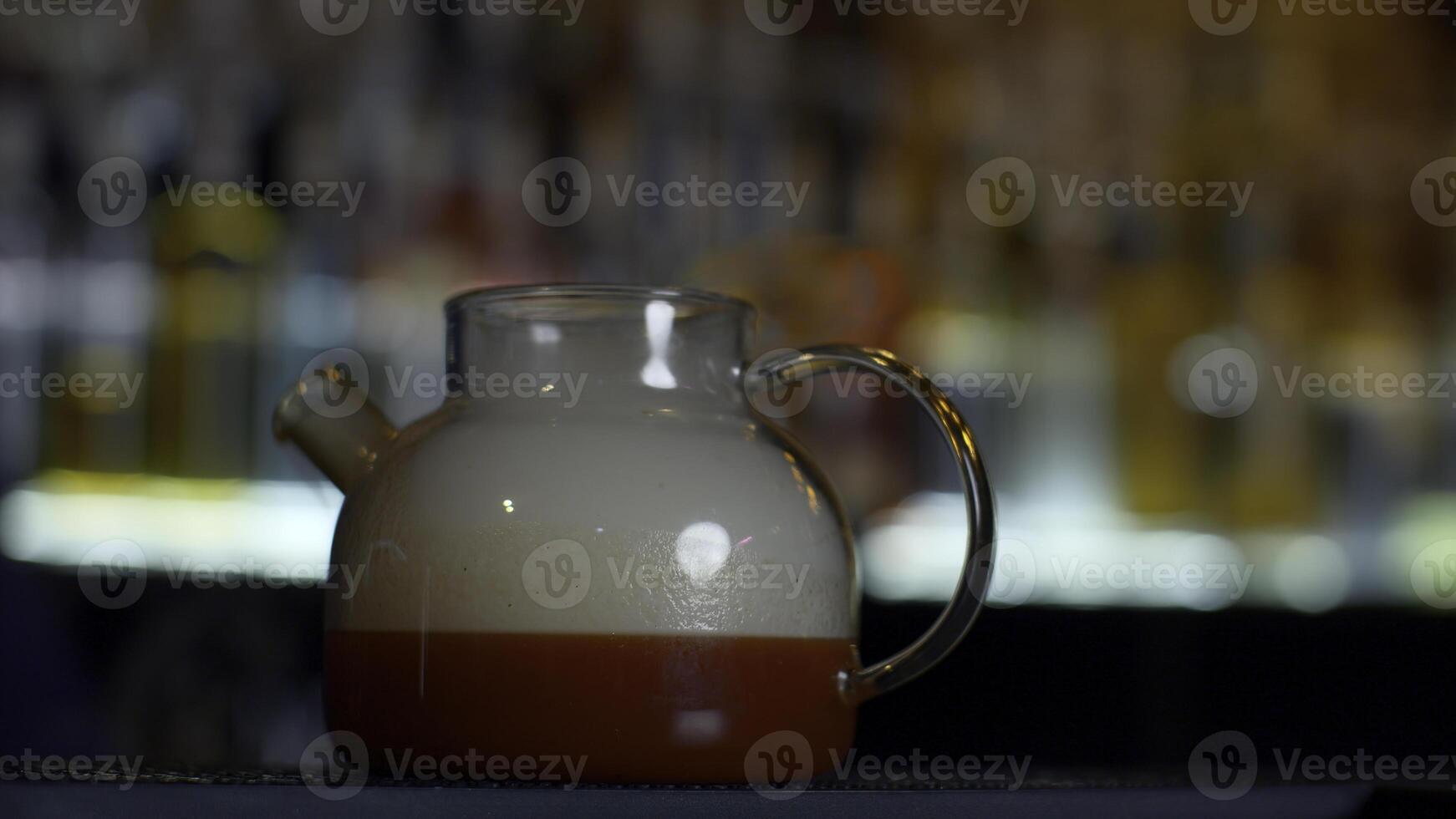 cerca arriba de haciendo rojo Fruta té a un bar o restaurante. medios de comunicación. barman agregando fumar dentro el té maceta mediante el tubo. foto