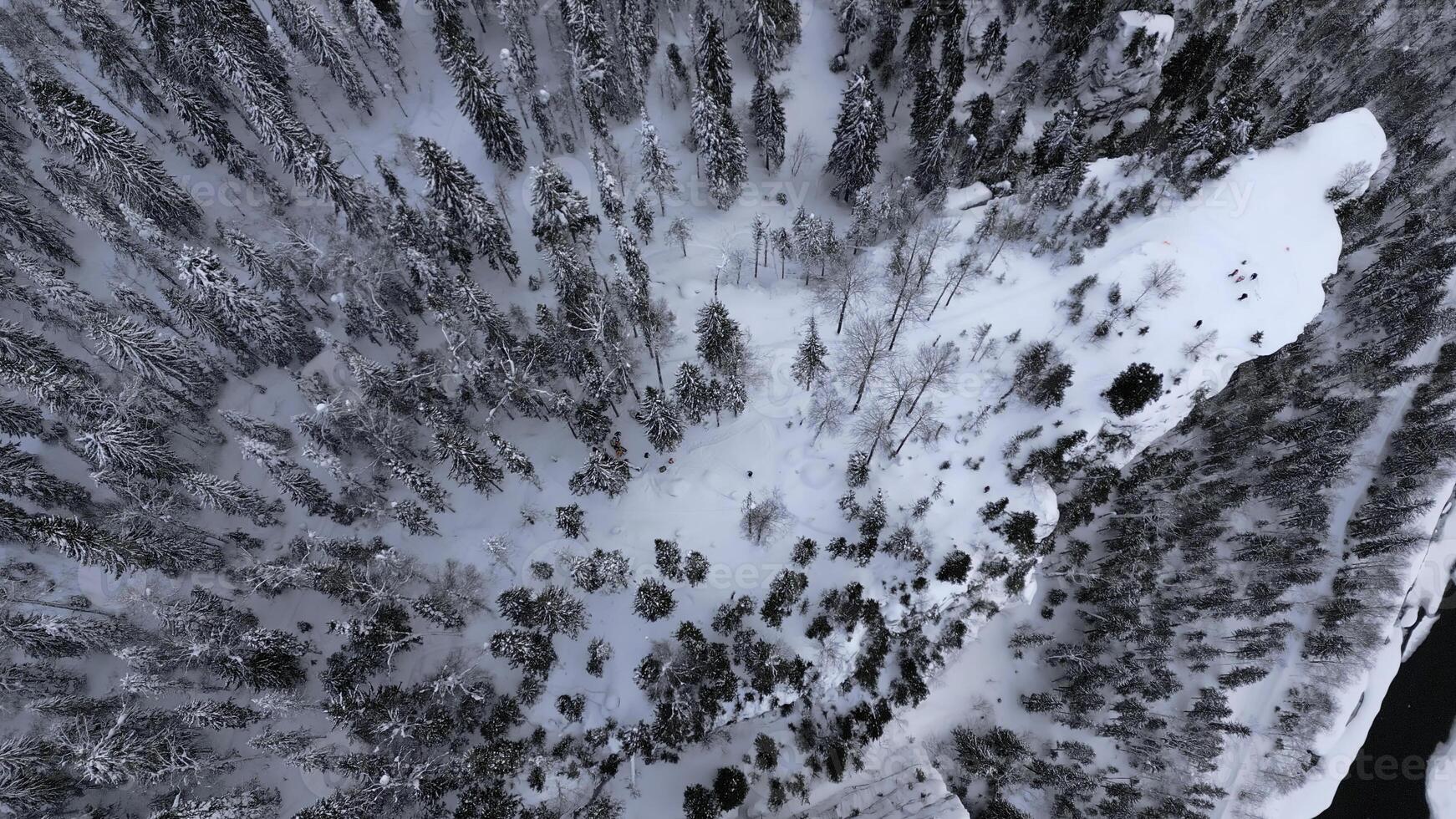 Aerial view of high stone formations in winter forest. Clip. Exploring frozen winter nature, concept of adventure. photo