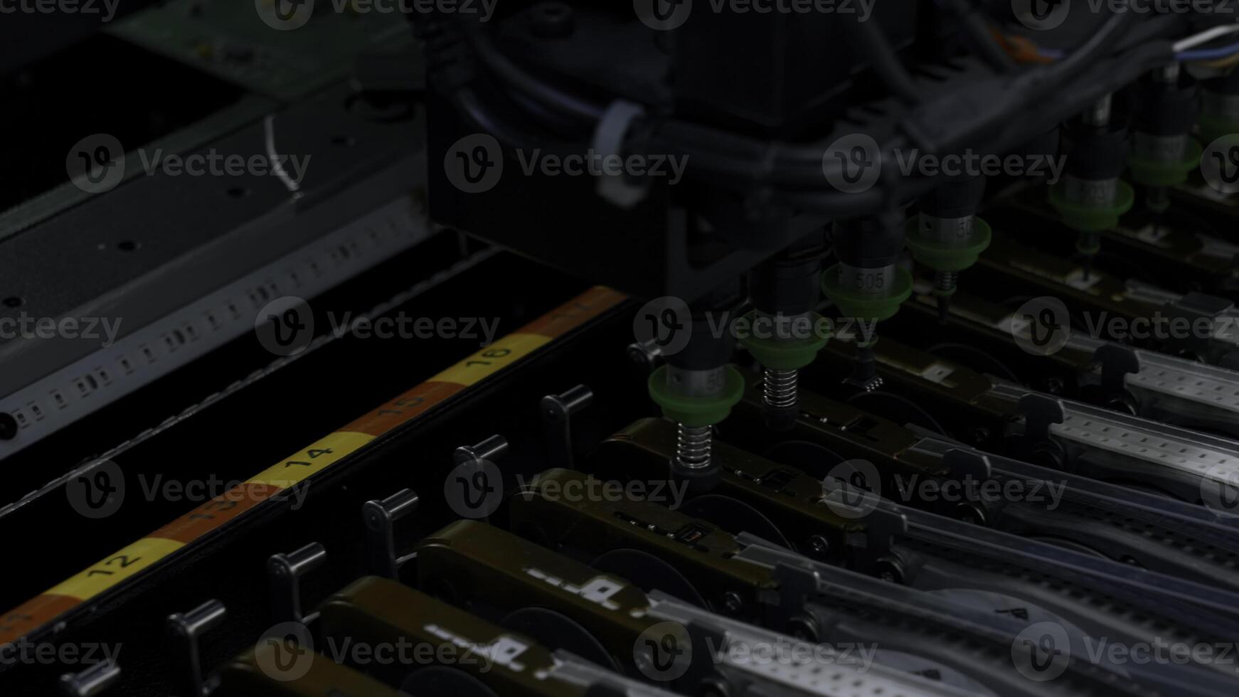 Close up of details of automatic SMD pick and place machine during work. Creative. Assembly of computer printed circuit board at factory. photo