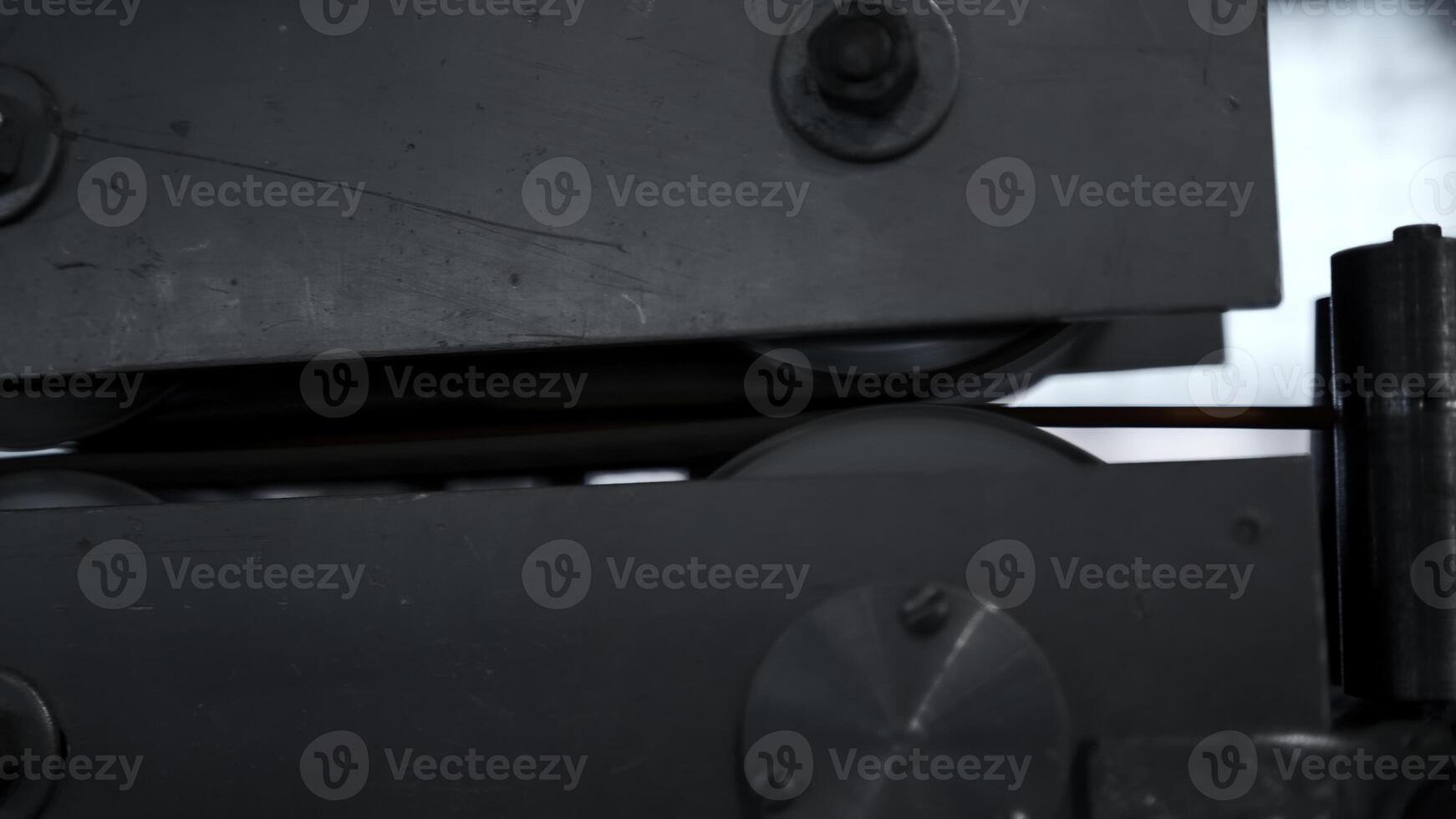 Close up of steel coils in a metal factory with moving fast wires covered by insulation material. Creative. Details of factory workshop. photo