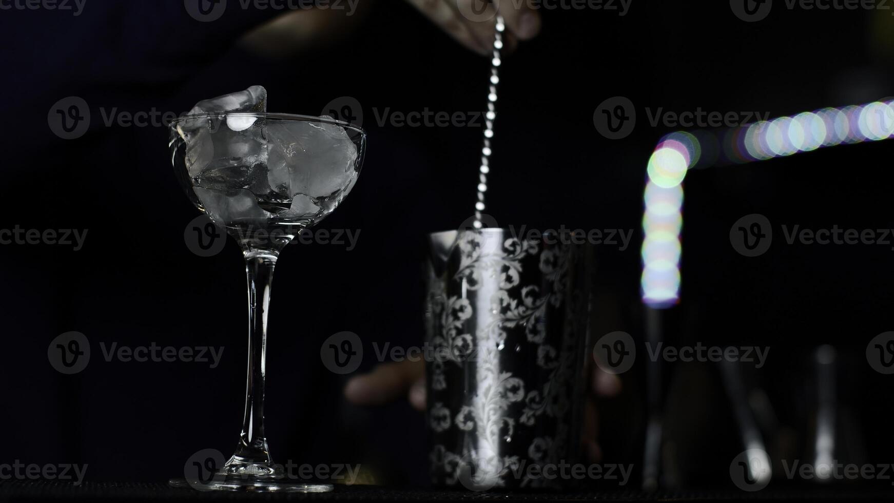 cerca arriba de un barman es mezcla un alcohólico cóctel a el bar o disco club. medios de comunicación. proceso de haciendo un un alcohólico beber. foto