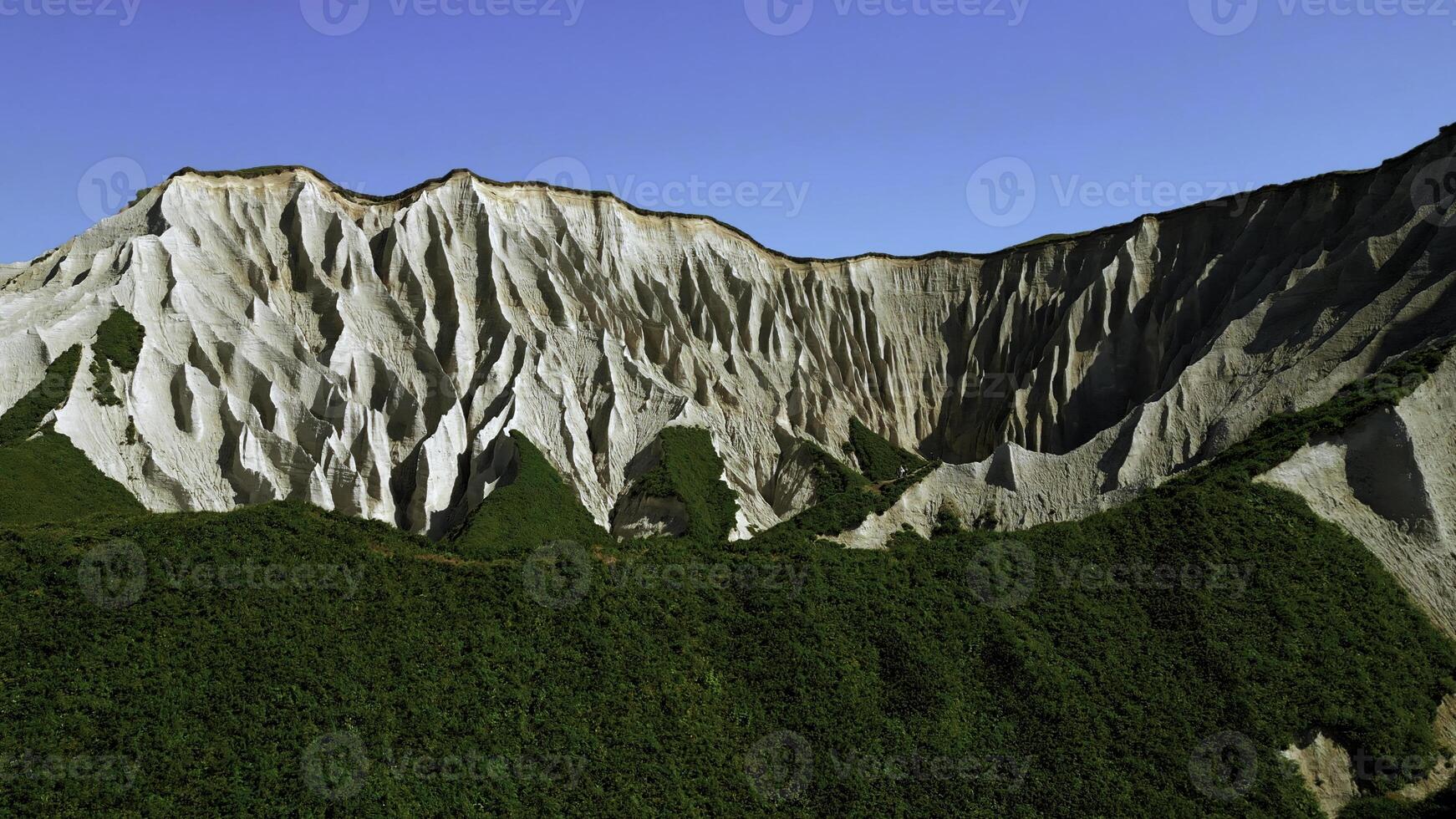 Beautiful aerial of the white cliffs on the south coast of England. Clip. Green summer forested hills and blue sky. photo