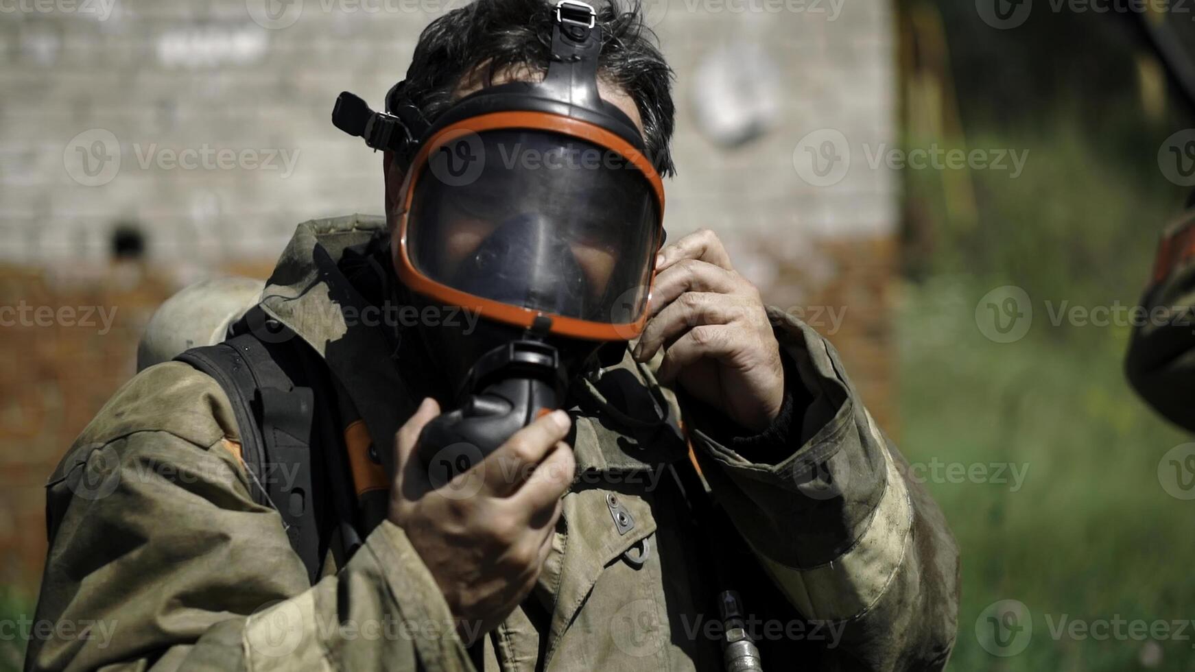 Close up portrait of strong serious fireman in mask. Clip. Concept of saving lives, heroic profession, fire safety. photo