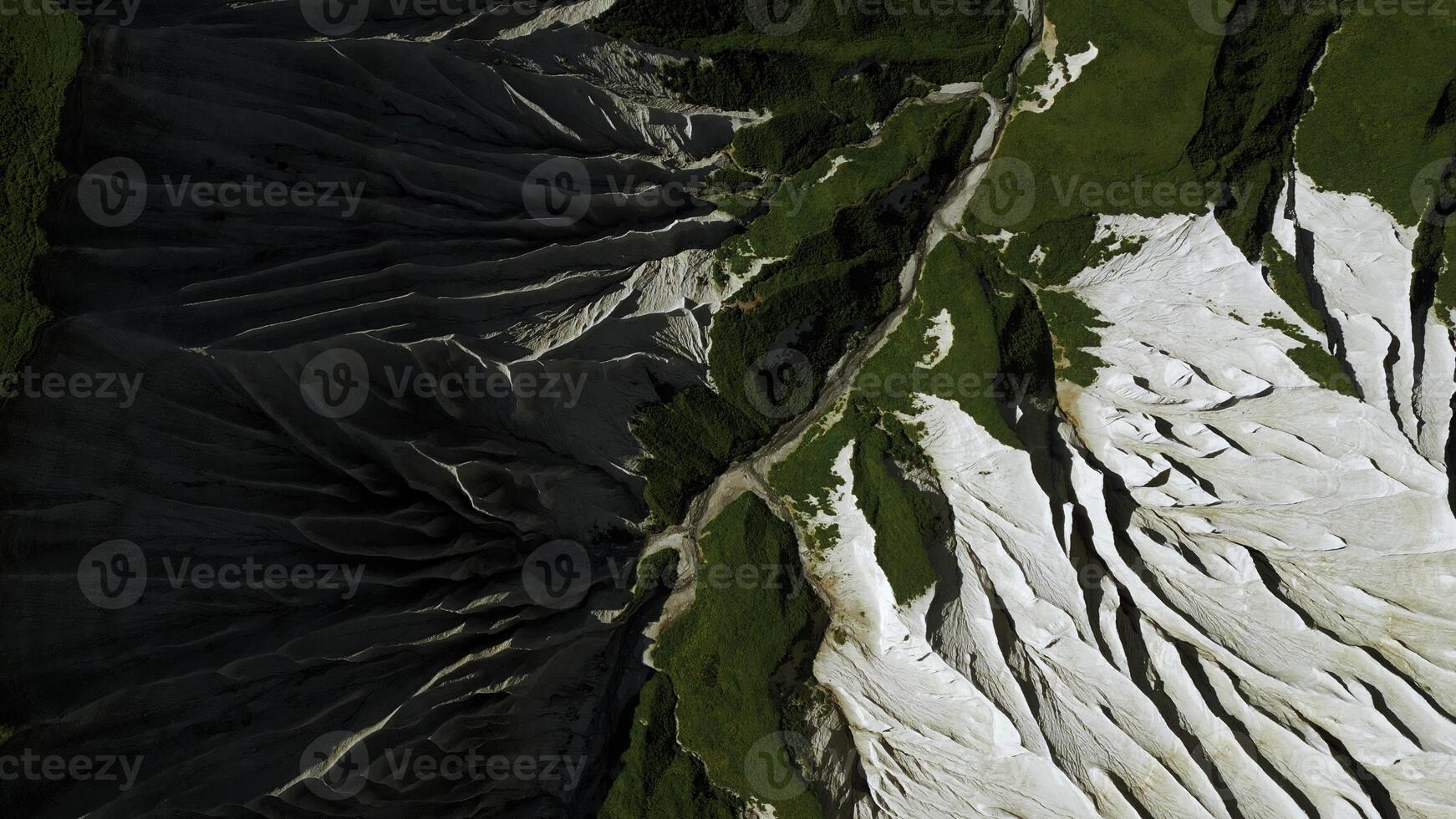 Top view of picturesque mountain peak. Clip. Frozen stone formations and green grass. photo