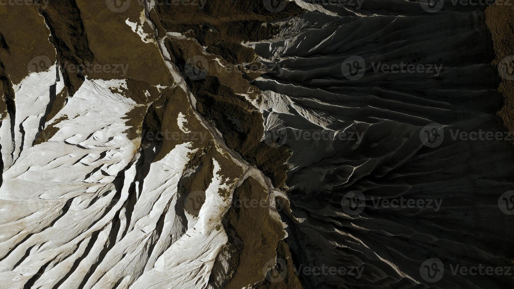 Aerial of wide gorge with rocky cliffs from both sides of small canyon. Clip. Stone slopes and yellow autumn grass. photo