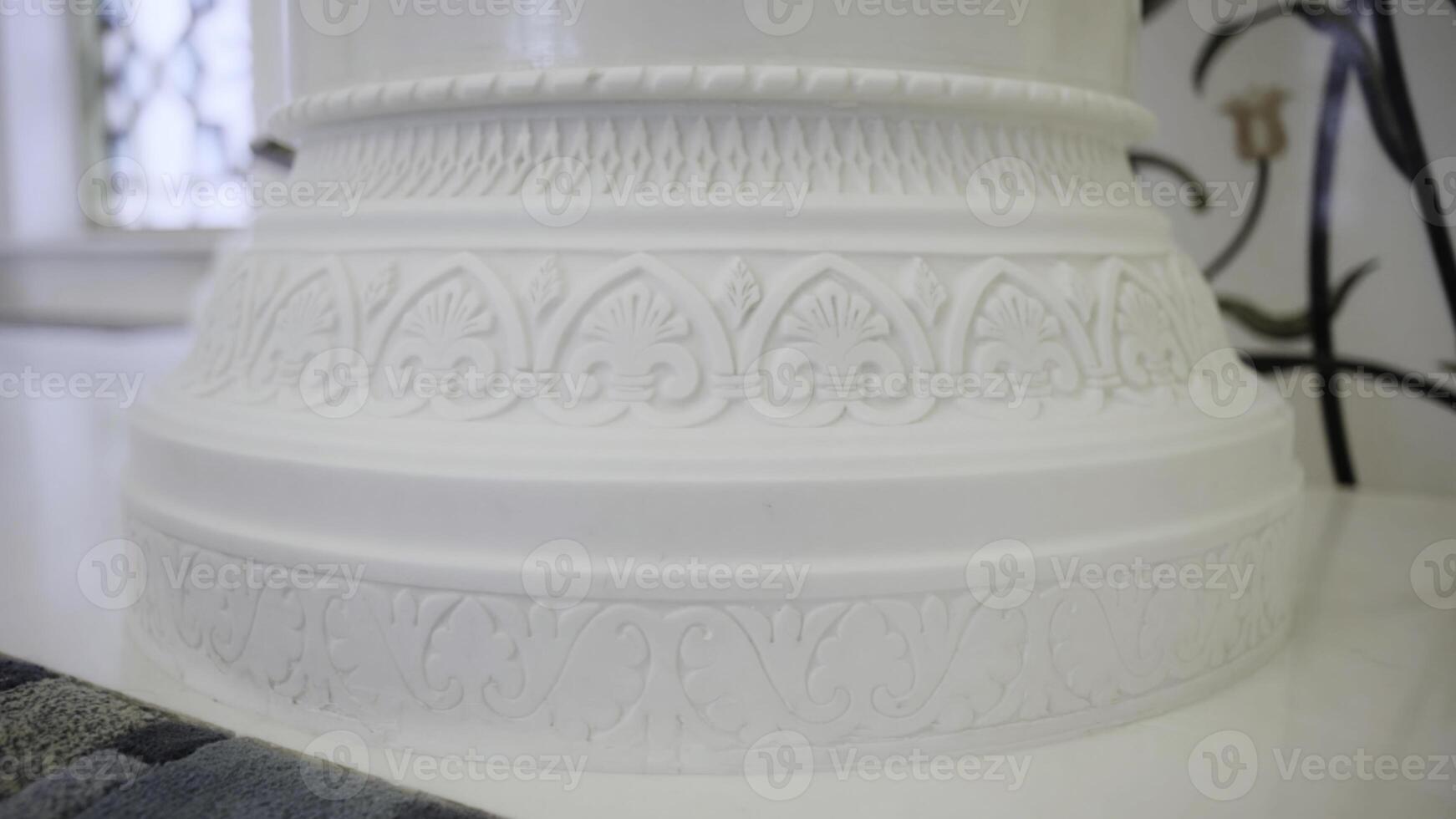 Close up of white beautiful pillar with carved pattern. Scene. Interior details of a white mosque. photo