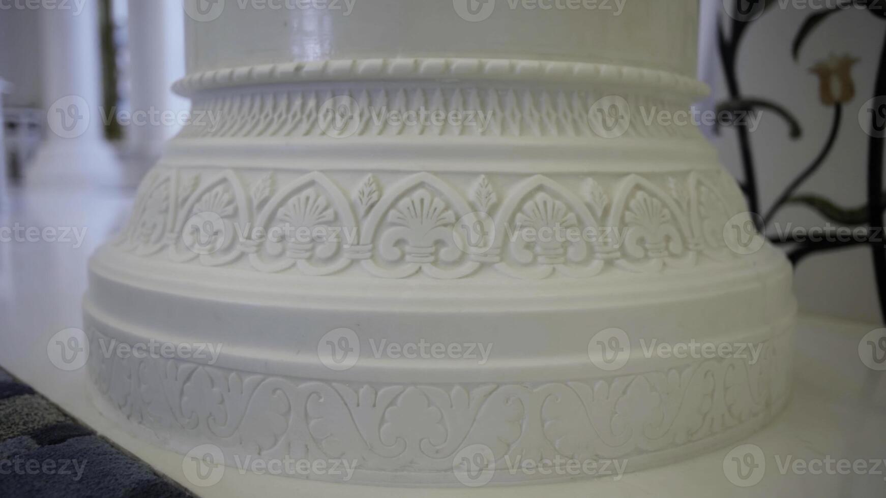 Close up of white beautiful pillar with carved pattern. Scene. Interior details of a white mosque. photo