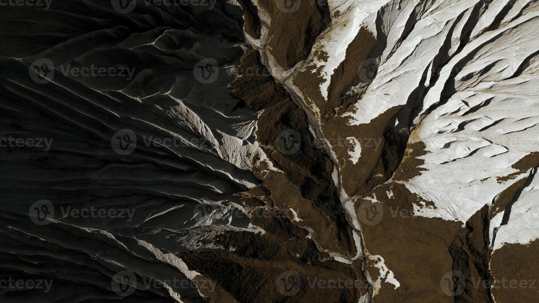 Aerial top view of the mysterious mountain rocks. Clip. White stone layers and brown ground. photo