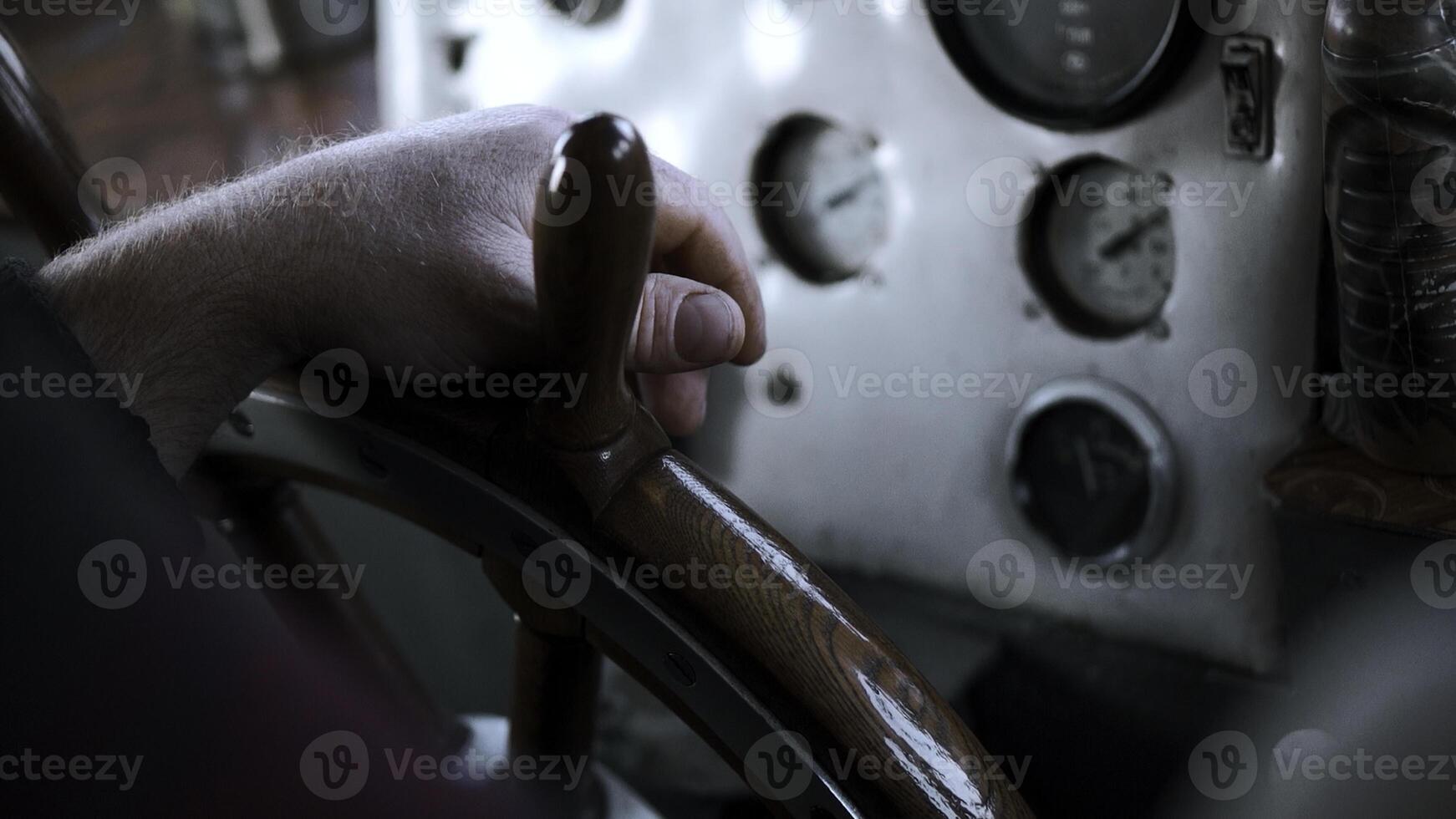 The ship's captain turns the wheel of the ship. Clip. Close up of man hand turning wooden steering wheel. photo