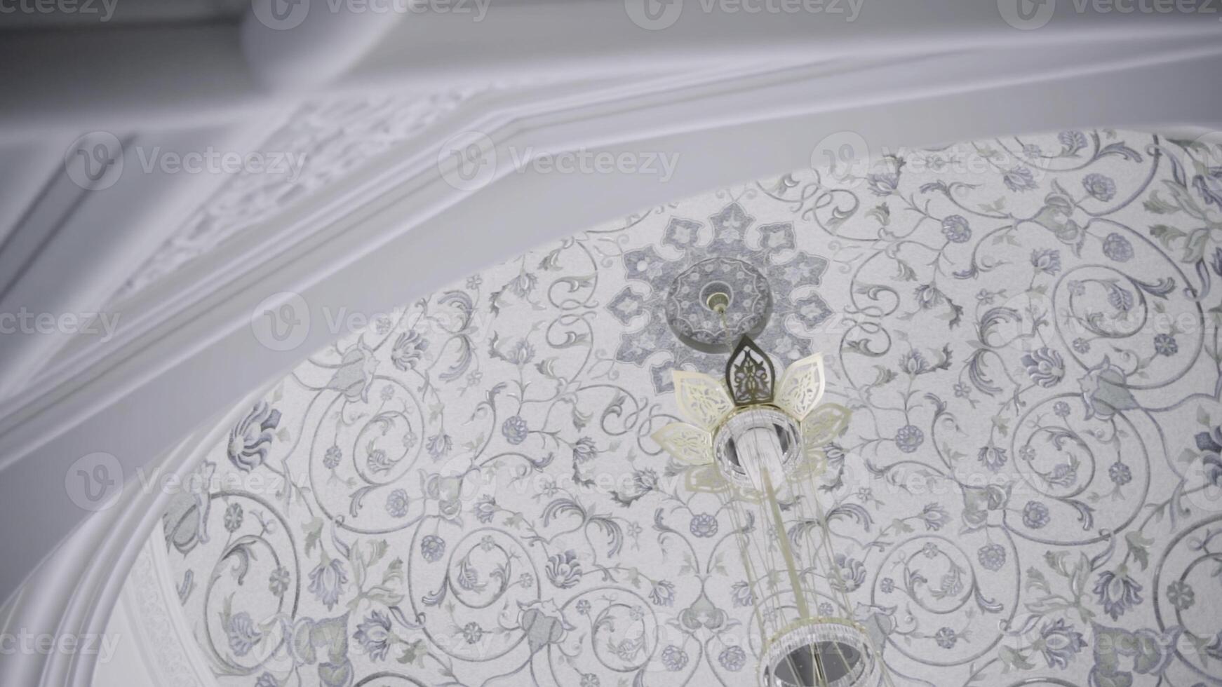 Beautiful white mosque details. Scene. Marble exterior wall of the temple with carved elements and the dome shape ceiling with hanging chandelier. photo