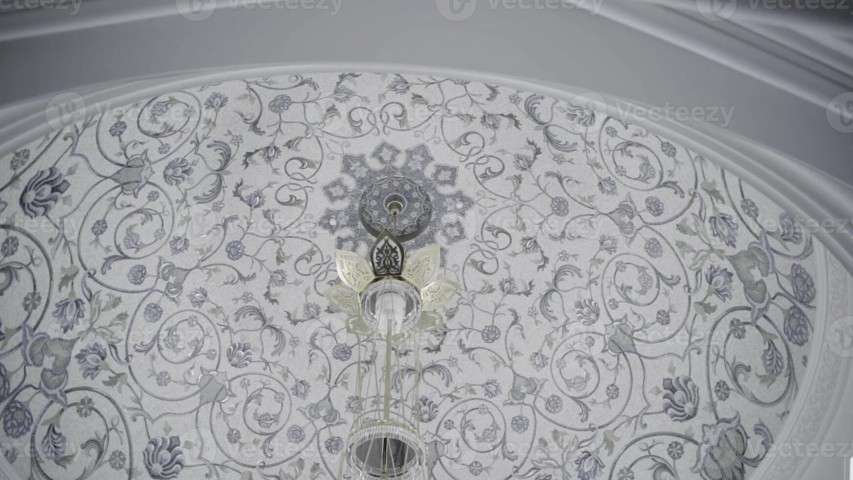 Decorative ceiling in a form of a dome with blue floral pattern. Scene. Hanging small chandelier, bottom view. photo