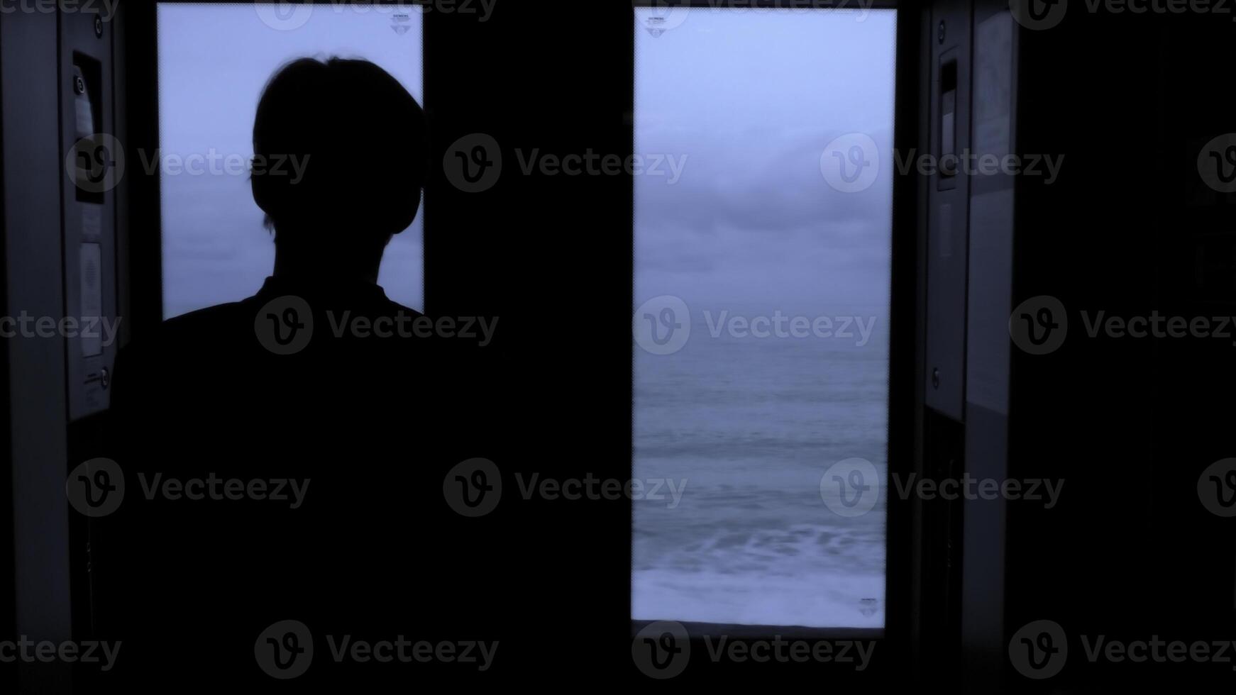 Man traveling by train and looking through the window at the sea. Stock clip. Beautiful late evening seascape from the moving train. photo