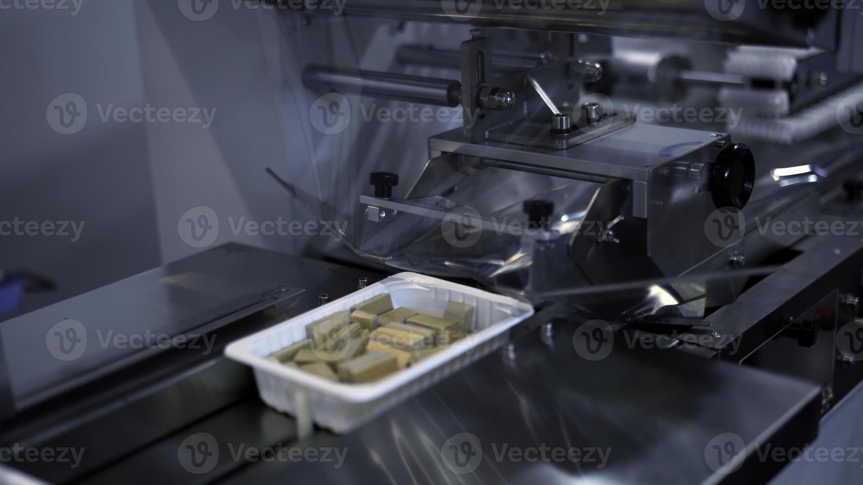 Plastic wrapping machine on production line. Media. Packing waffles at factory. photo