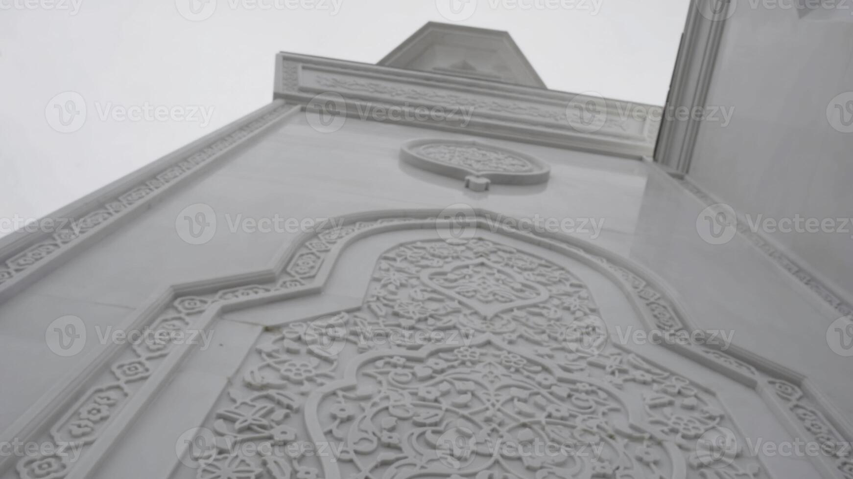 Beautiful white mosque details. Scene. Marble exterior wall of the temple with carved elements. photo