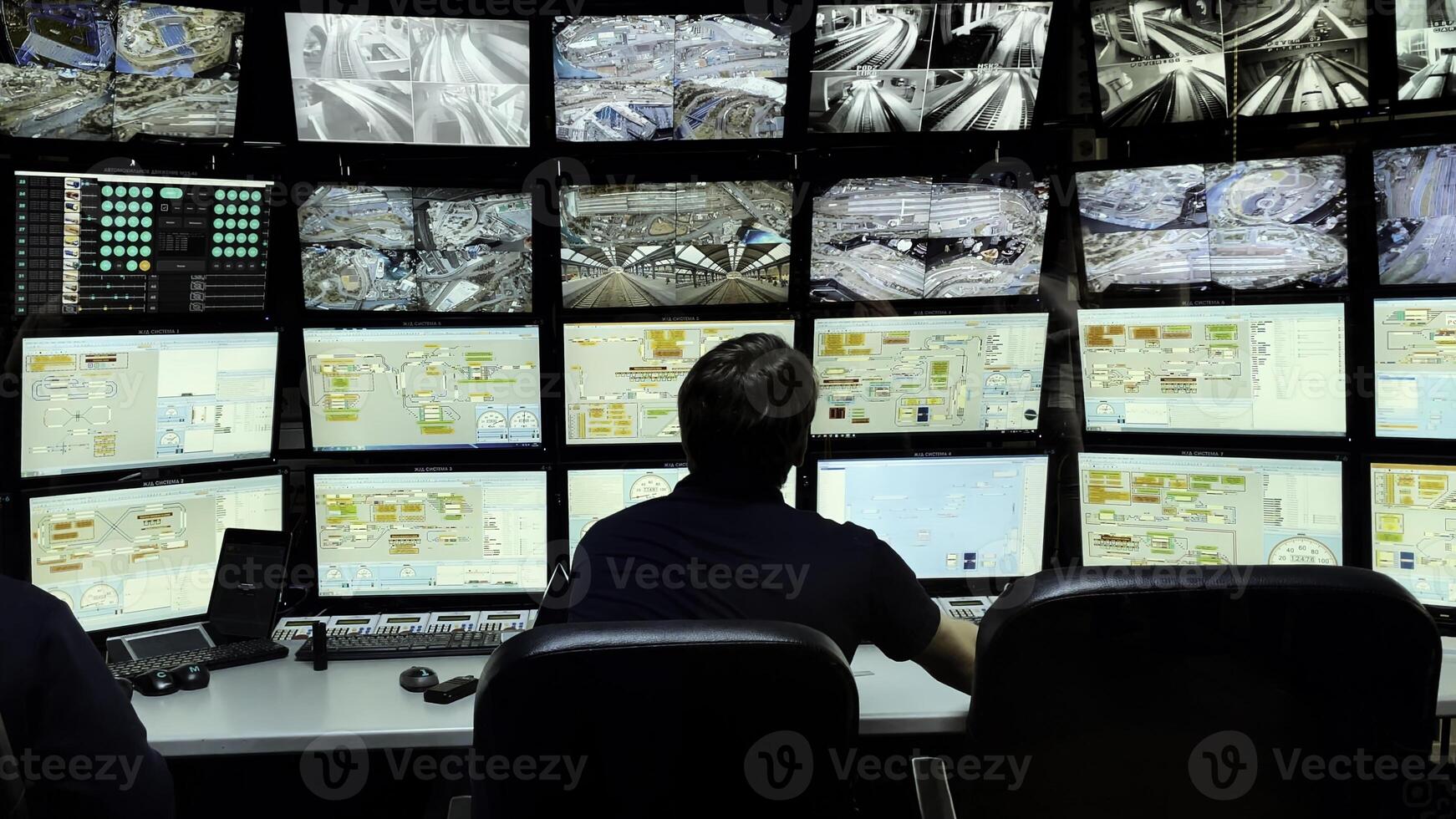 Security officer controls CCTV cameras in office, uses digital tablet and computers. Media. High tech software showing surveillance cameras, concept of social safety. photo