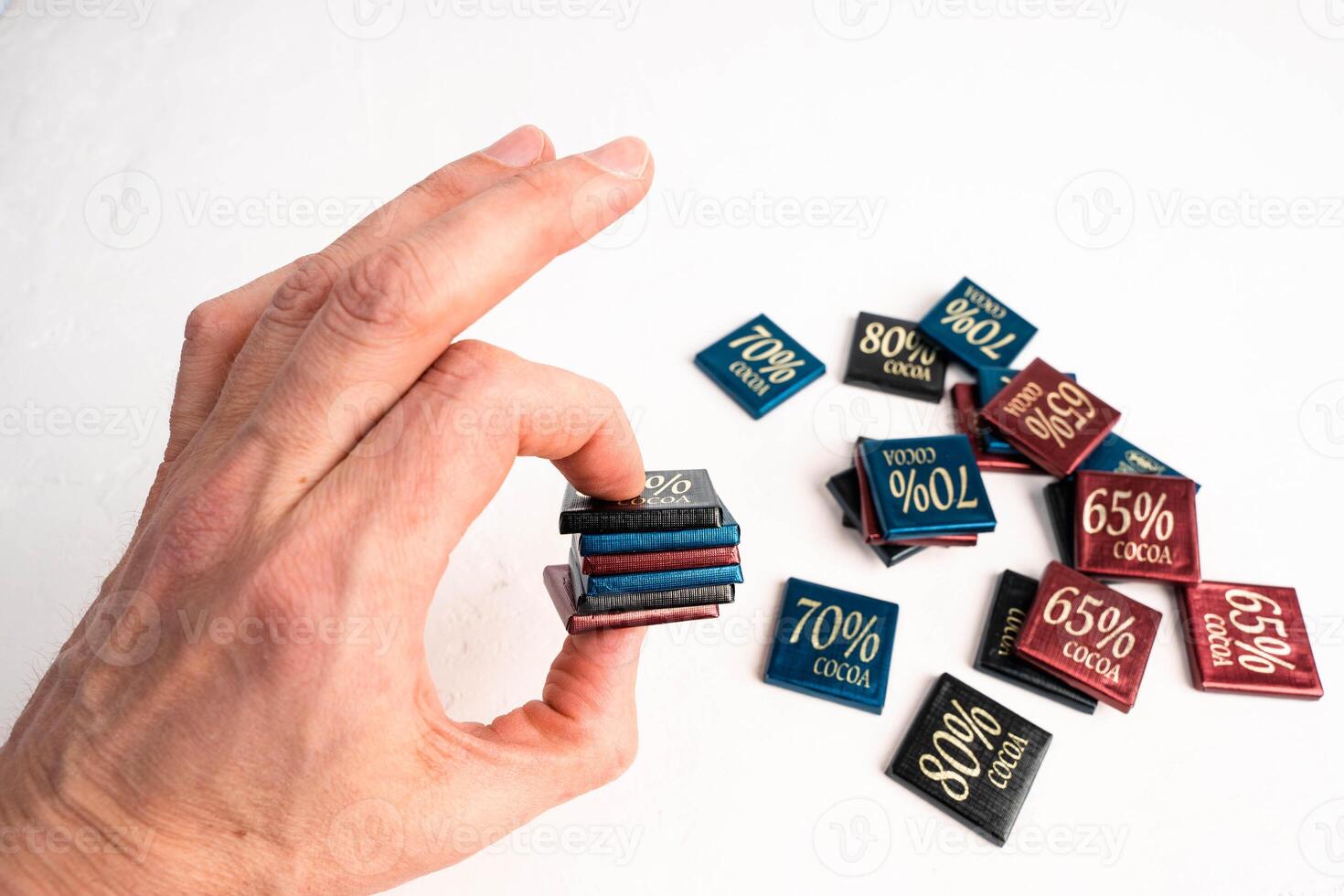 man holding box of chocolate bars with 65, 70, and 80 percent cocoa content photo