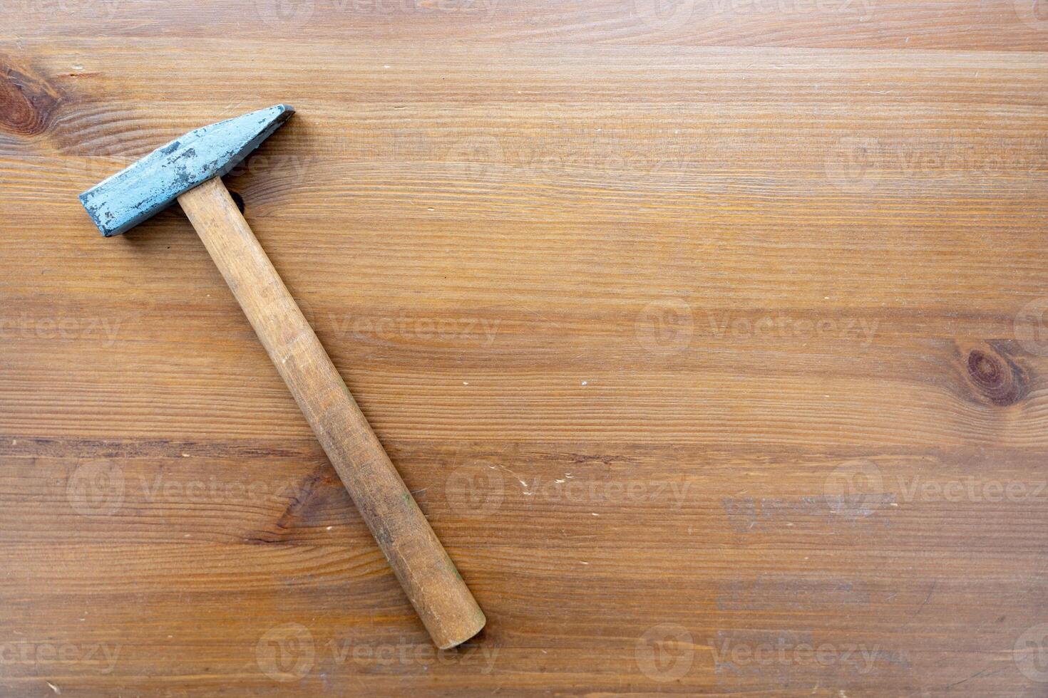 Blue-Handled Hammer on Wooden Surface photo