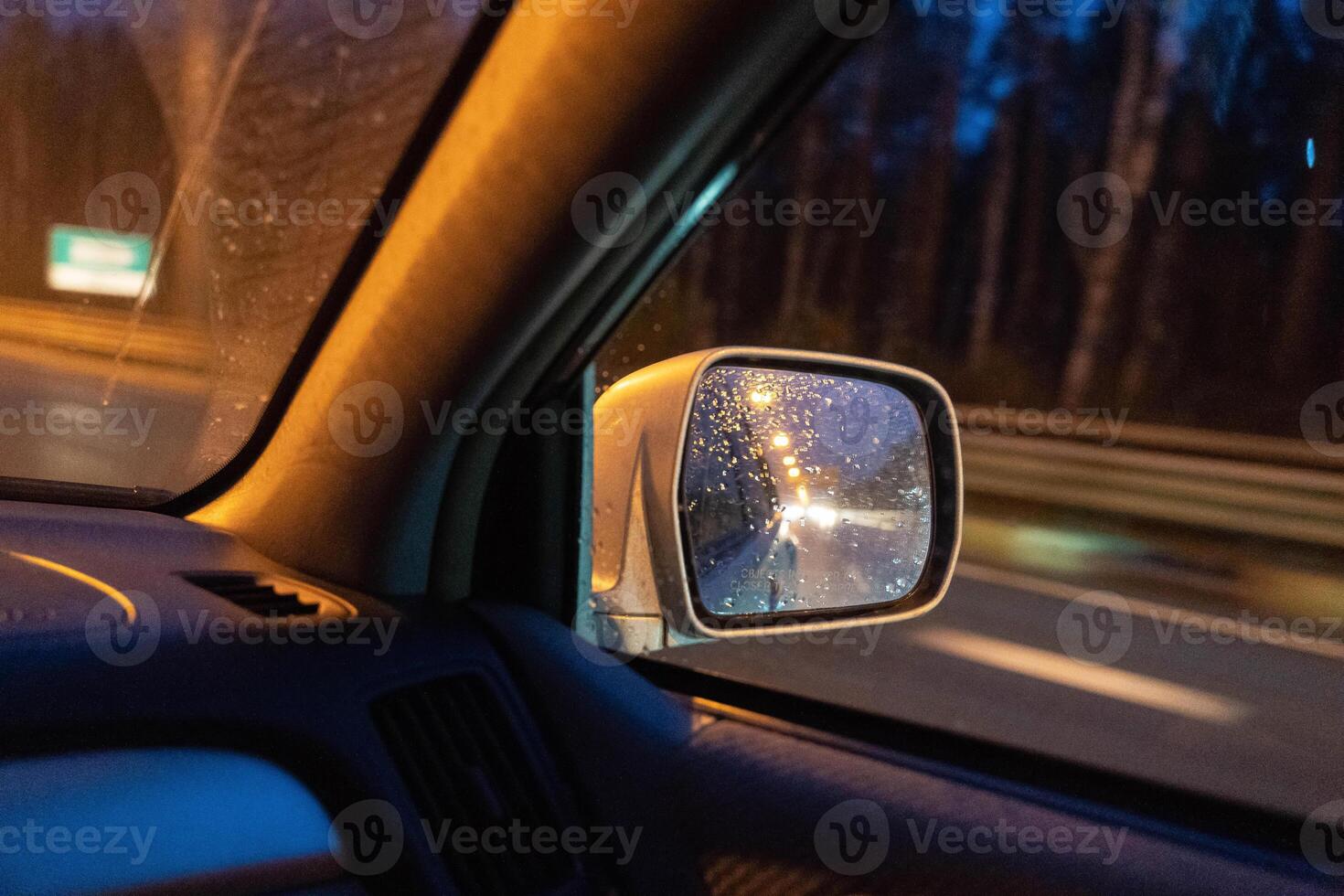 Spectacular night highway view through moving car windows with glowing lights and headlights photo