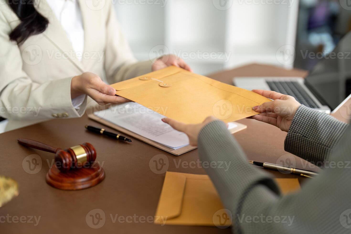 Businessman hands money envelope to lawyer in bribe over illegal business contract documents Investing, accepting bribes, corruption, fraud photo