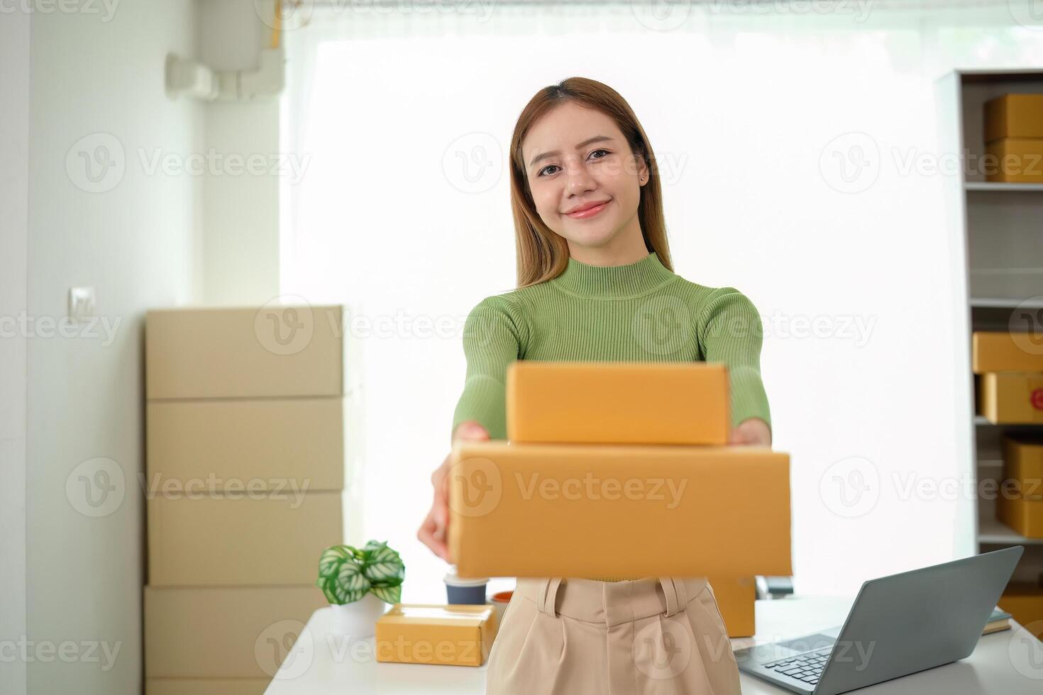 Young business woman asian working online ecommerce shopping at her shop. Young woman sell prepare parcel box of product for deliver to customer. Online selling photo