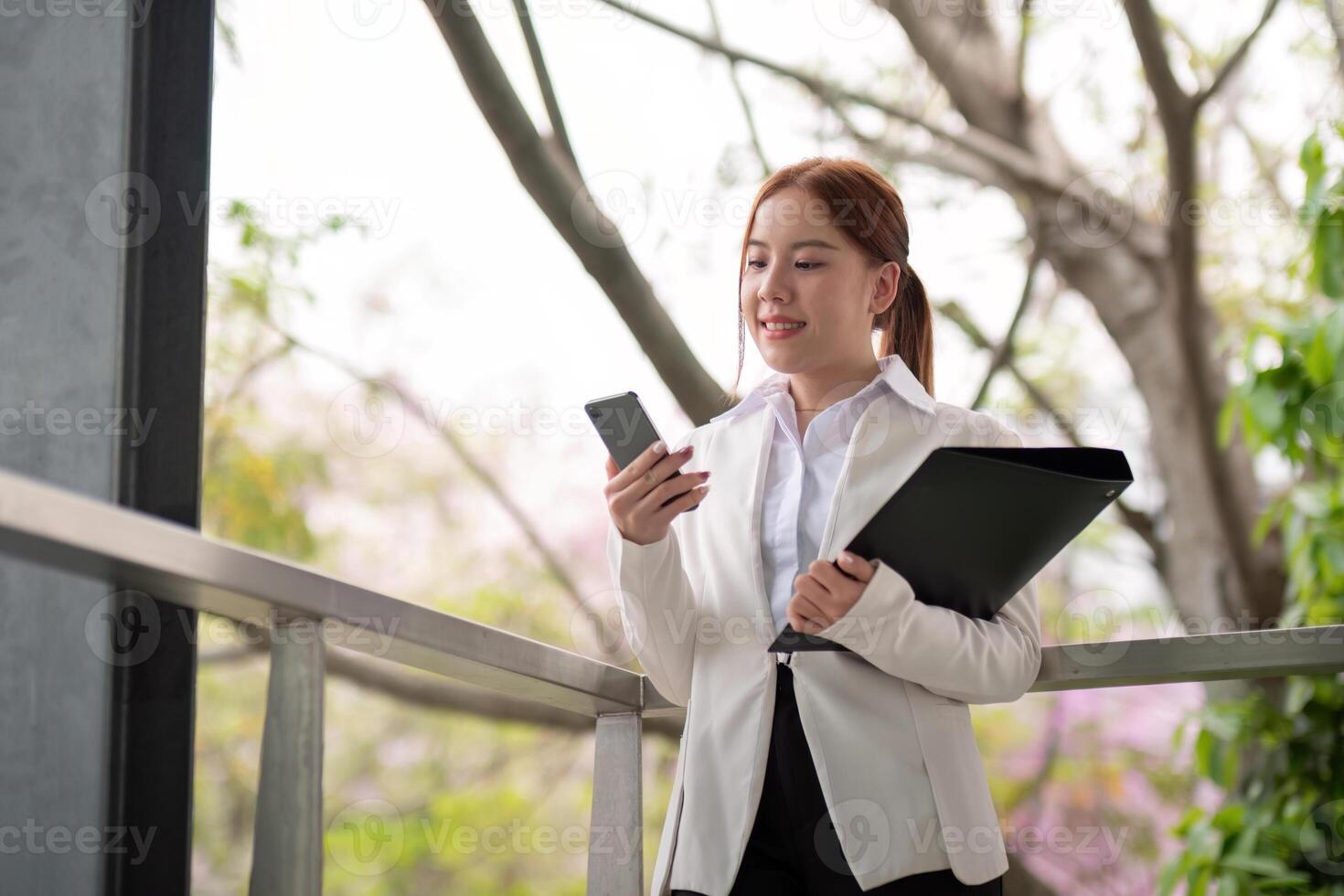 Asian business woman beautiful with smart phone and document file, asian woman with smartphone walking go to work. Preparation for the working day photo