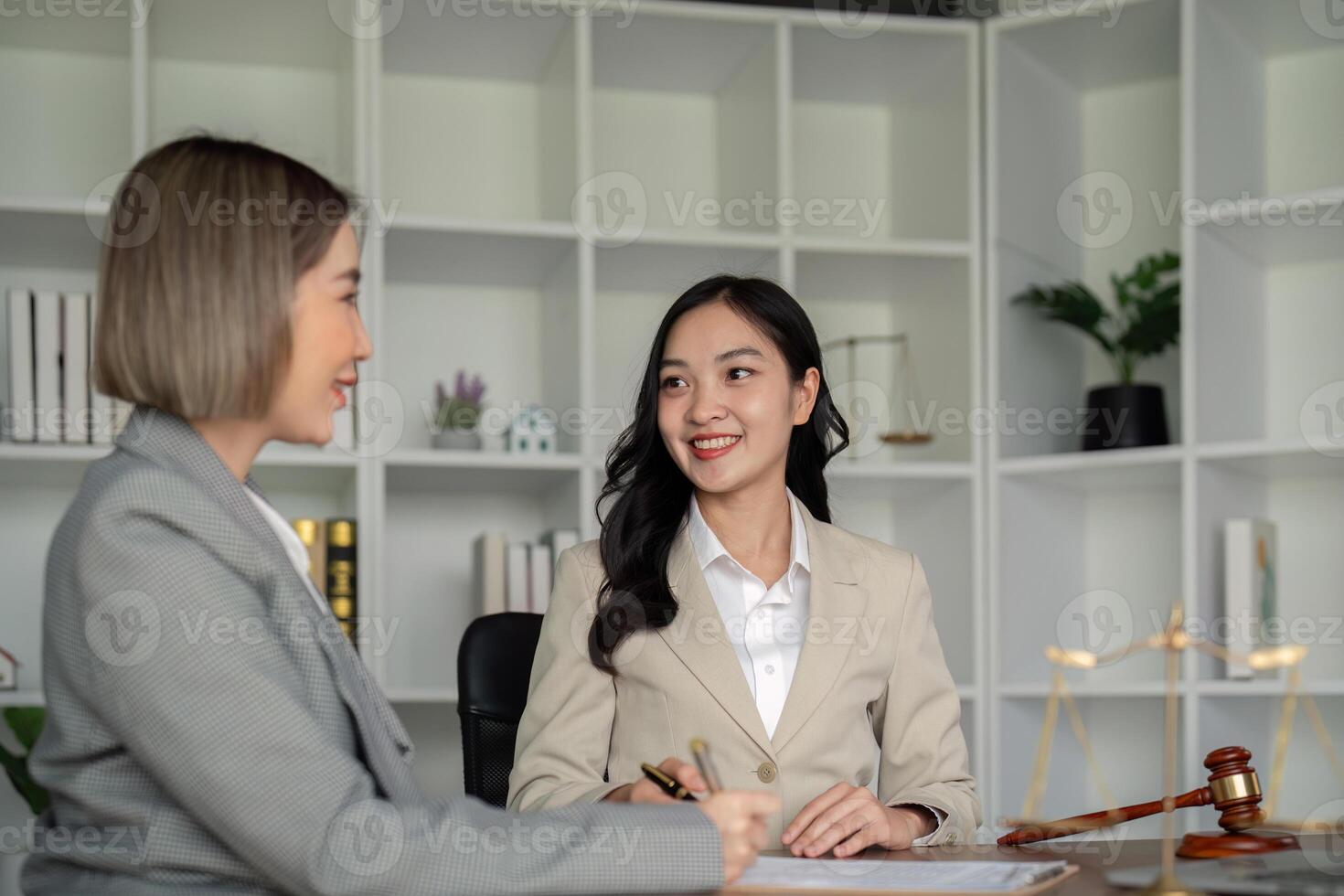 Lawyers woman and businesswoman discussing contract papers sitting at the table. Concepts of law, advice, legal service photo