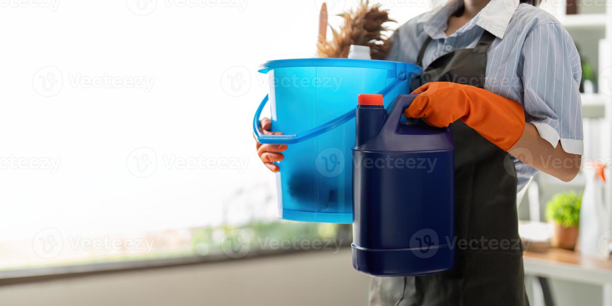 Young woman cleaning to disinfect the office office cleaning staff cleaning maid. Female cleaner holding a bucket with cleaning supplies photo