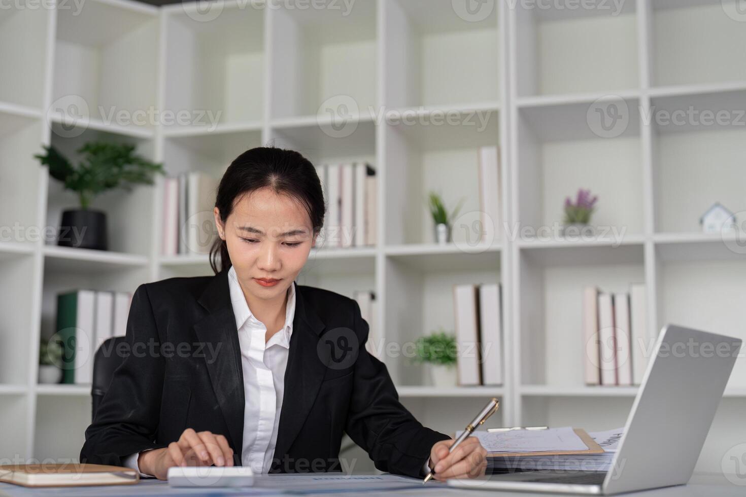 Young business woman asian or employee accounting bookkeeping documents checking financial data or marketing report working in office with laptop. Paperwork management photo