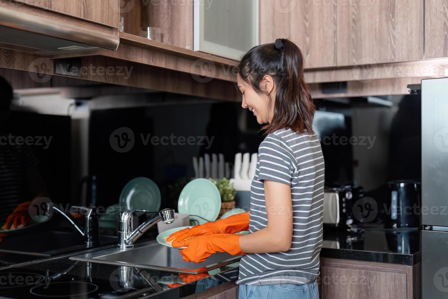 Woman asian washing up at home dishes in sink photo