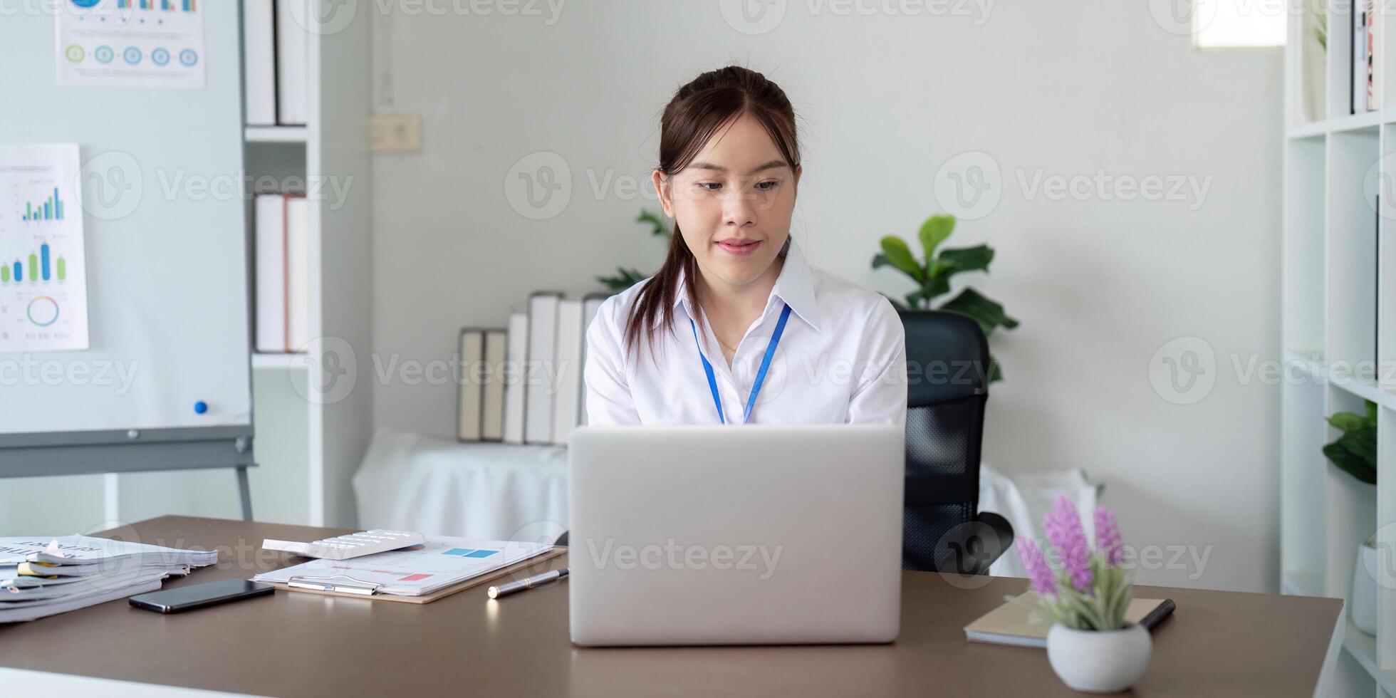 Asian business woman using laptop to analysis graph financial budget report and planning for future in office desk photo