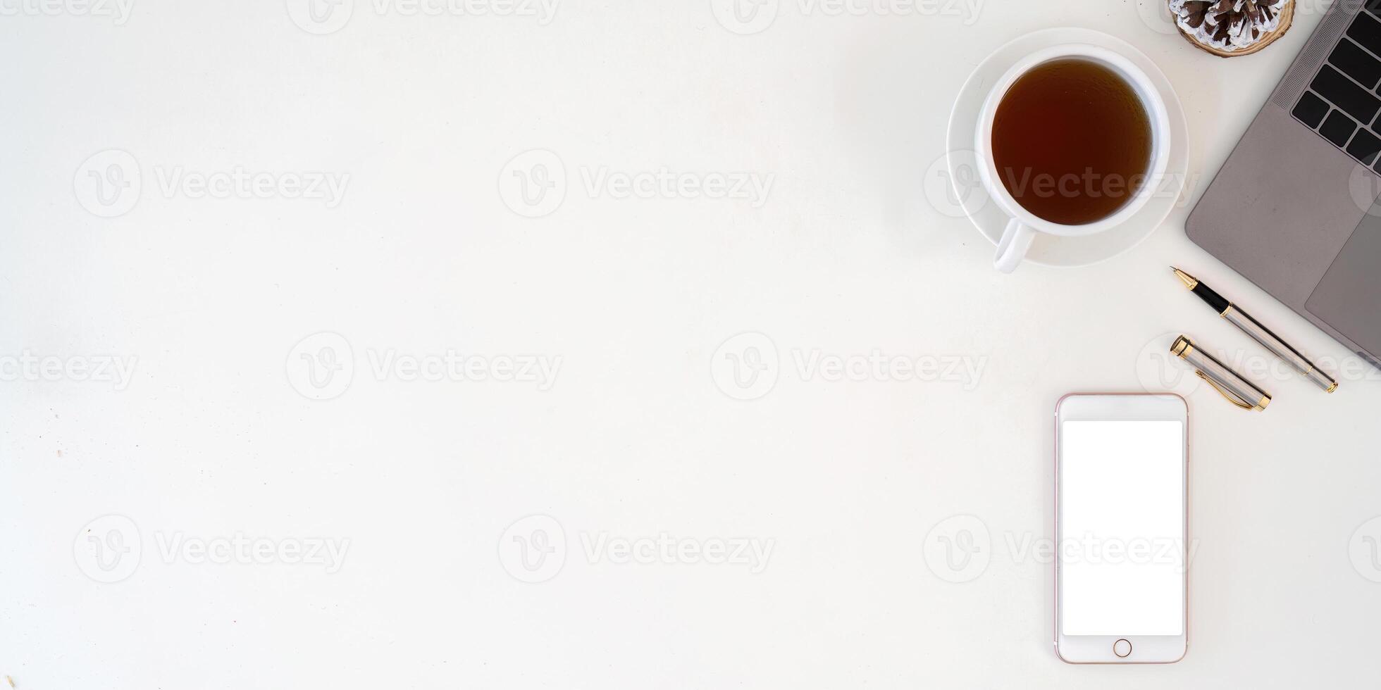 Top view smartphone with empty screen, Laptop and coffee cup on office desk. Copy space for your text photo