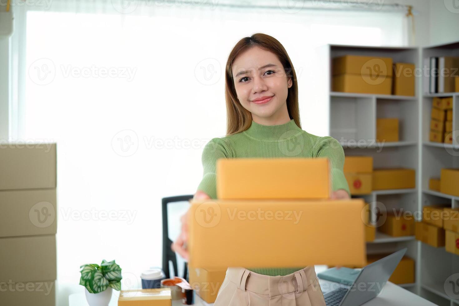 Young business woman asian working online ecommerce shopping at her shop. Young woman sell prepare parcel box of product for deliver to customer. Online selling photo