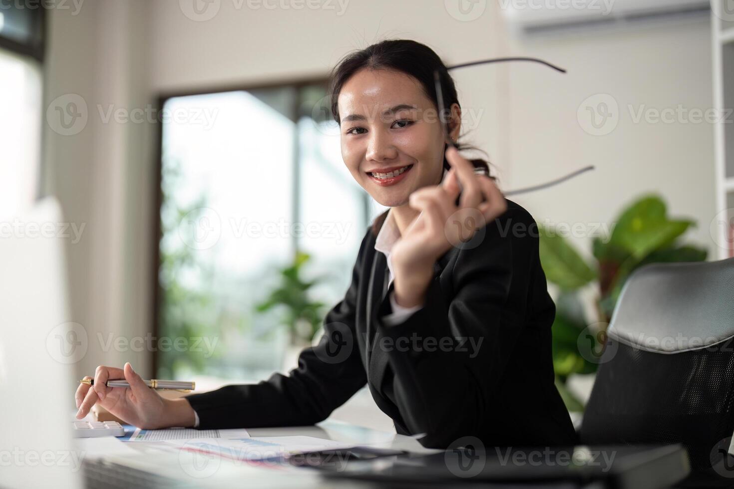 Young business woman asian or employee accounting bookkeeping documents checking financial data or marketing report working in office with laptop. Paperwork management photo