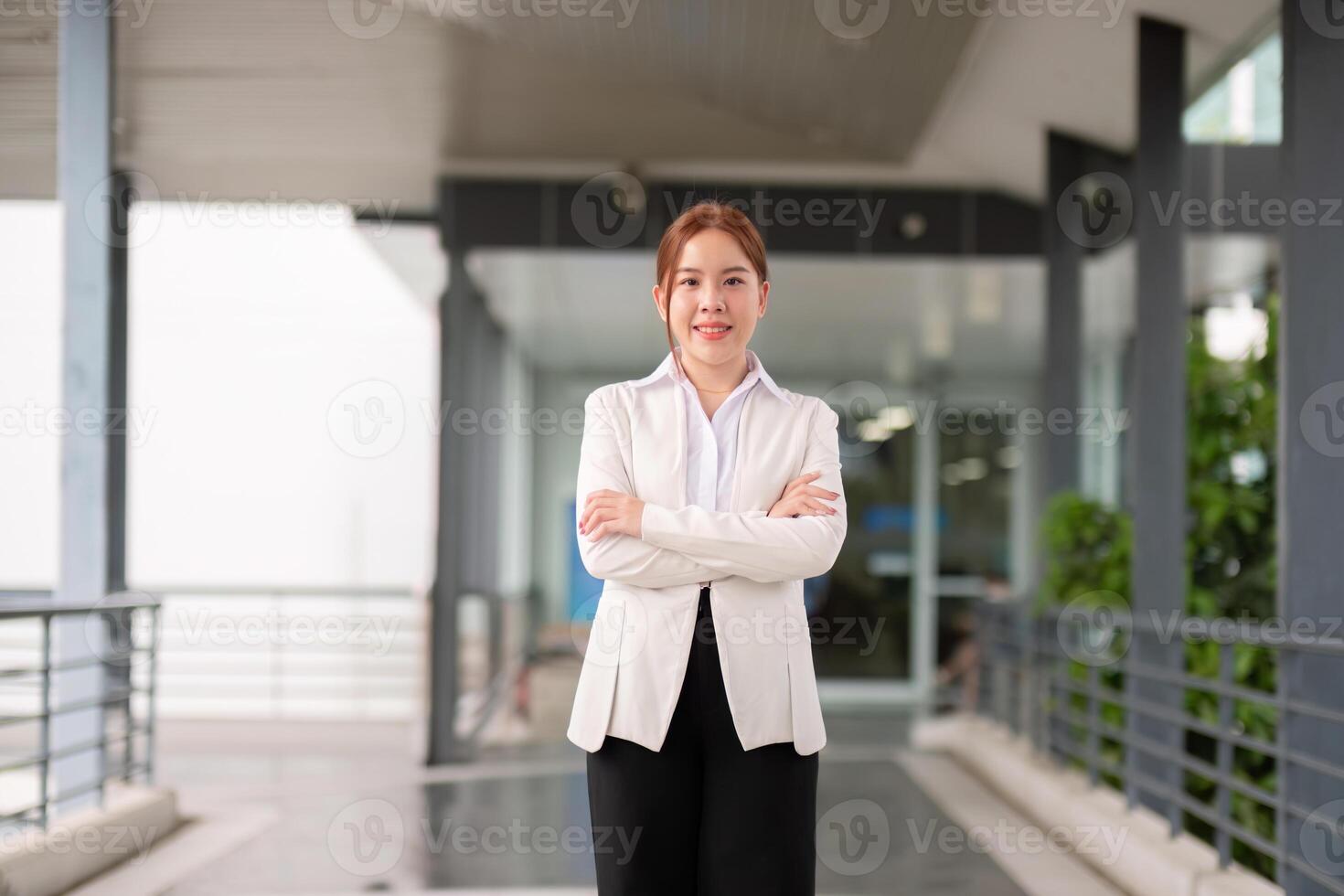 Young happy smiling professional business woman asian, happy confident positive female entrepreneur standing on street arms crossed, looking at camera photo
