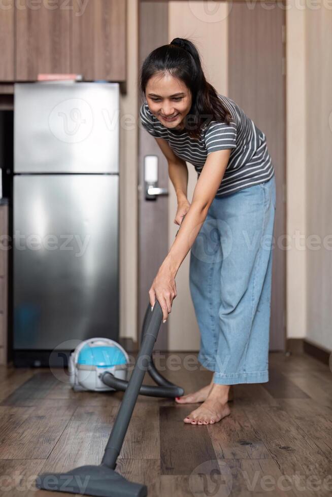 Young woman asian cleaning floor with vacuum cleaner in living room, Housework, cleanig and chores concept photo