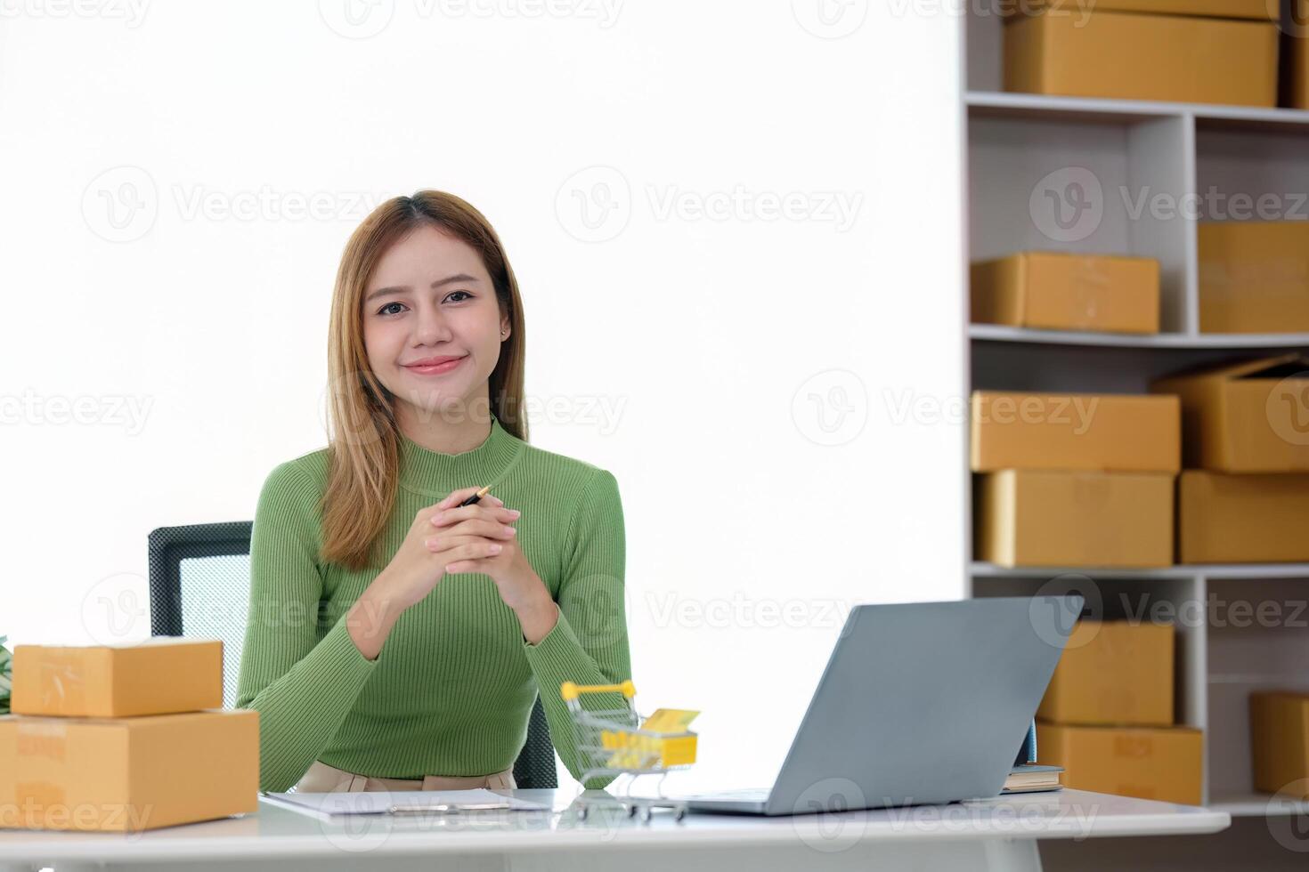 Young business woman asian working online ecommerce shopping at her shop. Young woman sell prepare parcel box of product for deliver to customer. Online selling photo