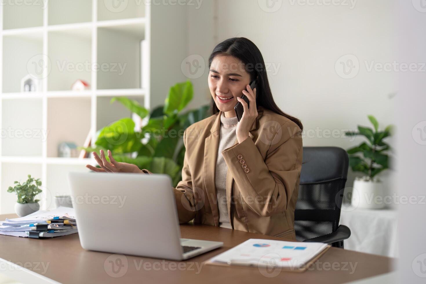 Work from home. Businesswoman using laptop computer and smartphone in her room. Eco friendly businesswoman working on desk, freelance, green room area, sustainable lifestyle concept photo
