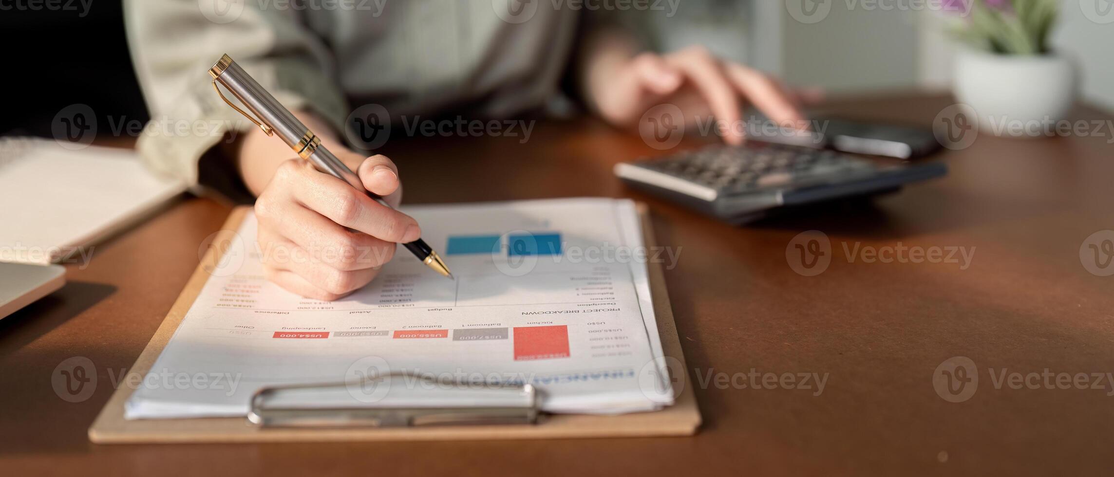 Businesswoman using laptop computer and working at office with calculator document on desk, doing planning analyzing the financial report, business plan investment, finance analysis concept photo