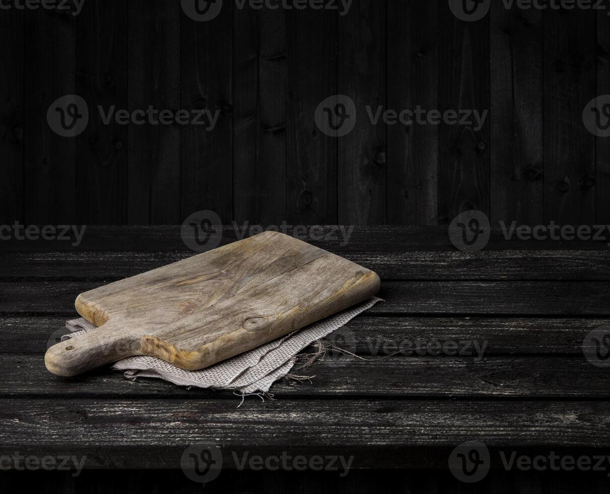 Dark wooden table with cutting board photo