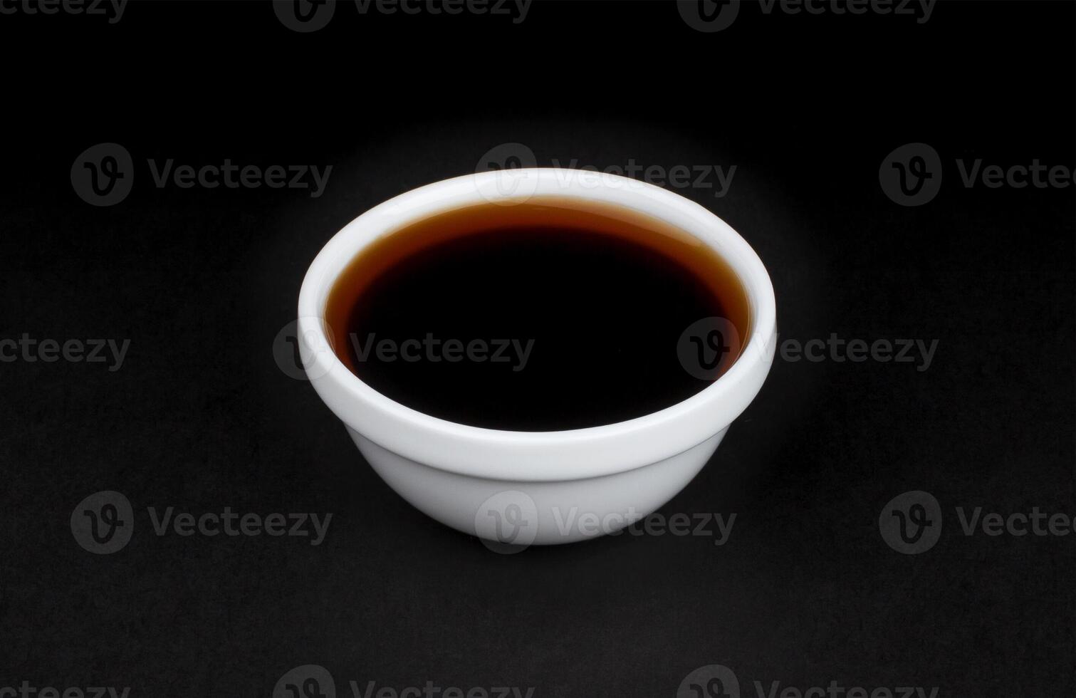 Soy sauce in white bowl on black background photo