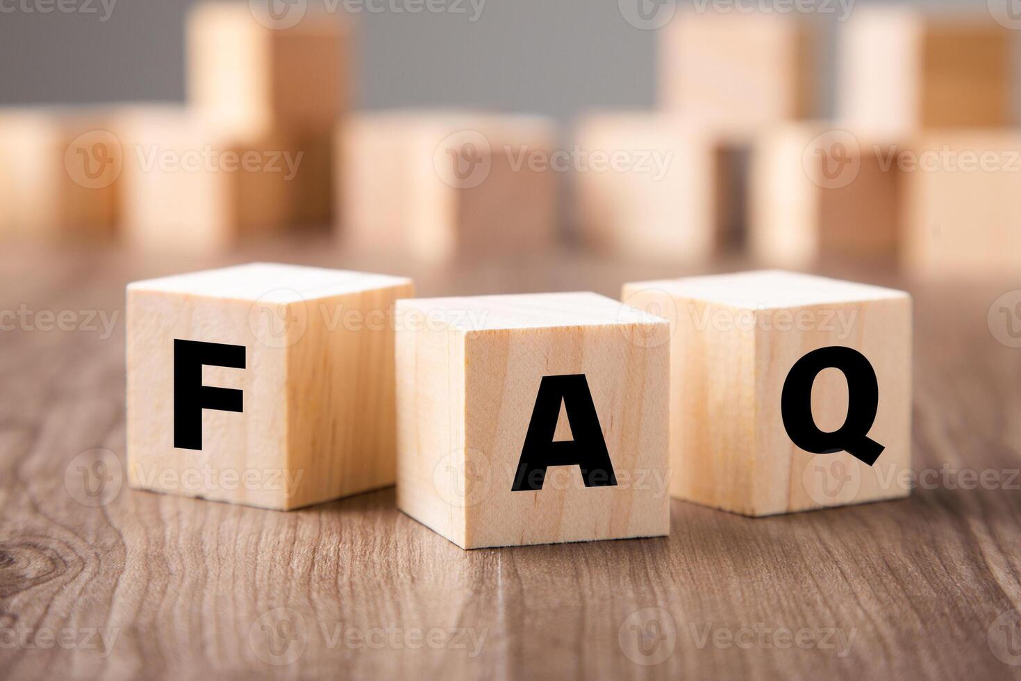 Frequently asked question concept. Wooden blocks with word FAQ on wooden background. photo