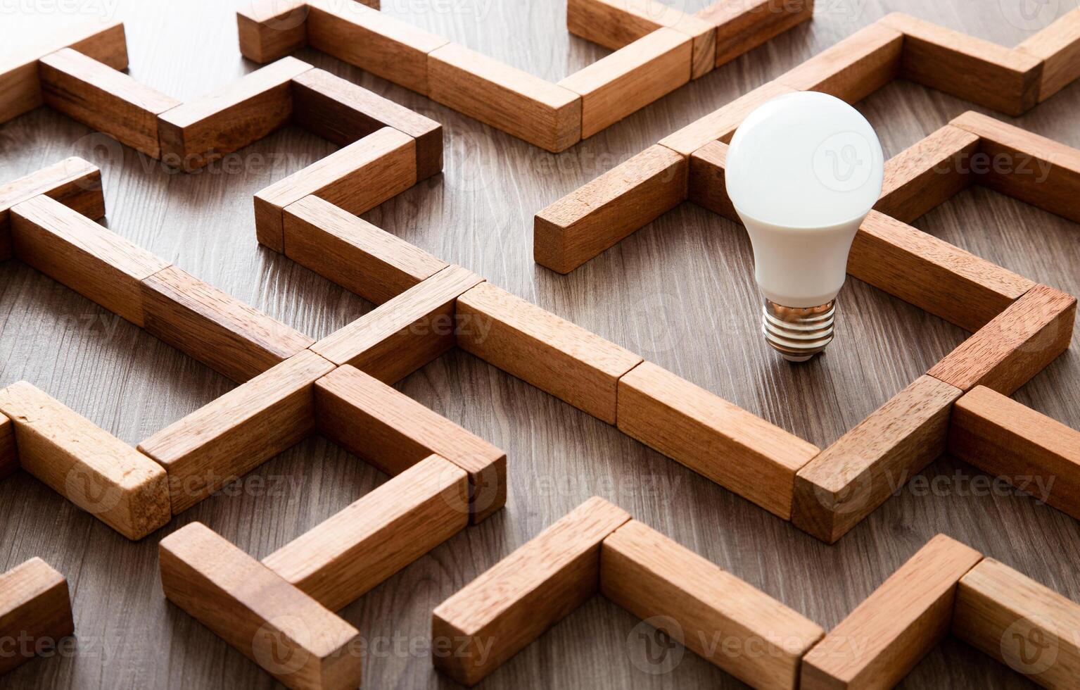 Light bulb in the maze game built by wood blocks, finding the right way to the success, idea concept photo