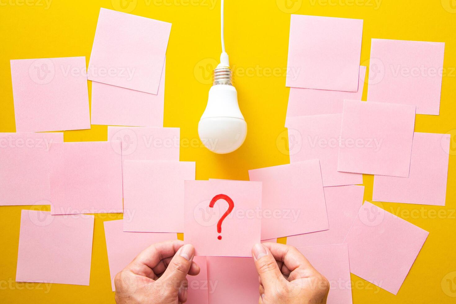 Question mark and light bulb on yellow background. The process of problem solving. photo