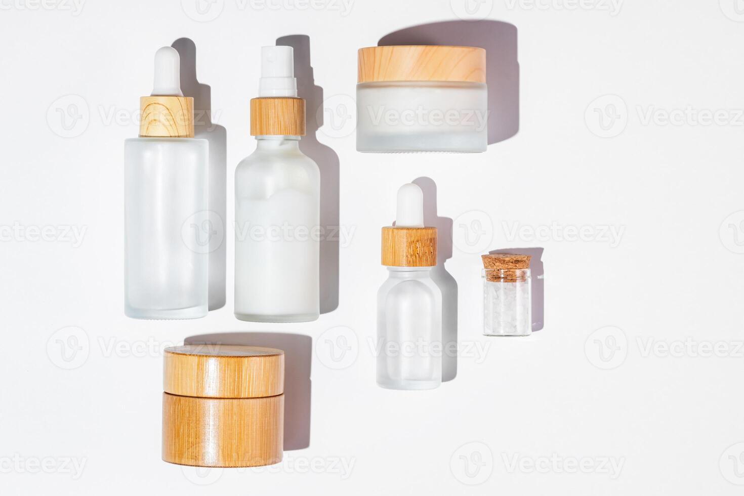 Set of skin care cosmetic products in eco package of white class and bamboo lids. Mockup for design, top view photo