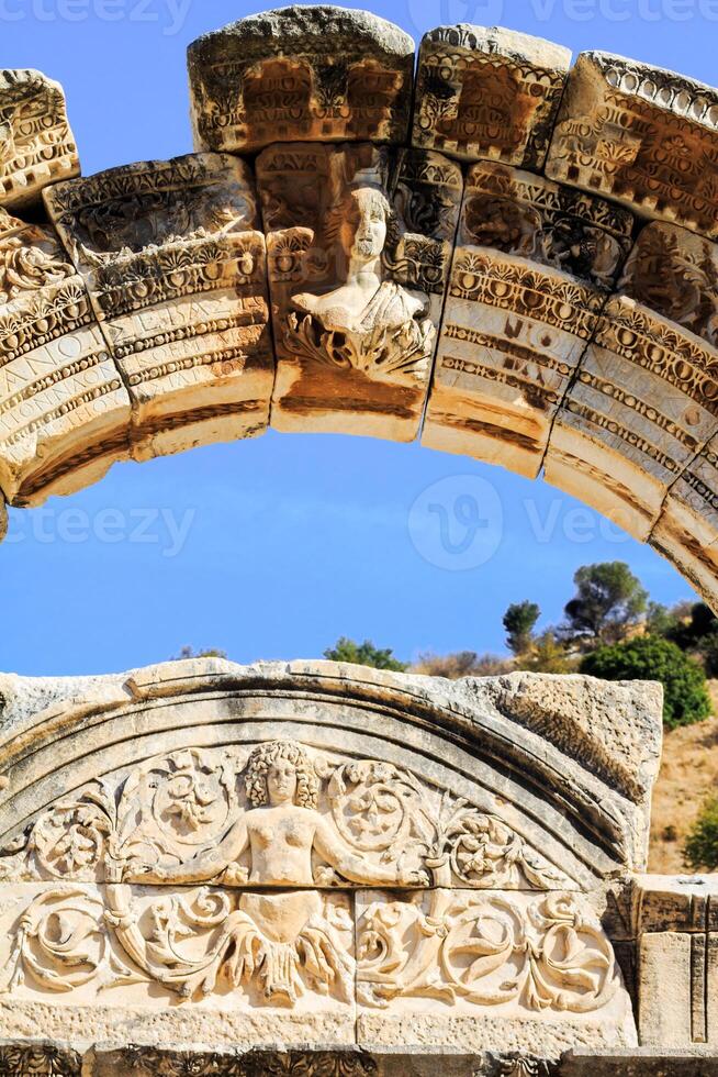View of Tyche, goddess of victory at the middle of curved arch in the front part of hadrian temple in the ancient city of ephesus, Turkey. photo