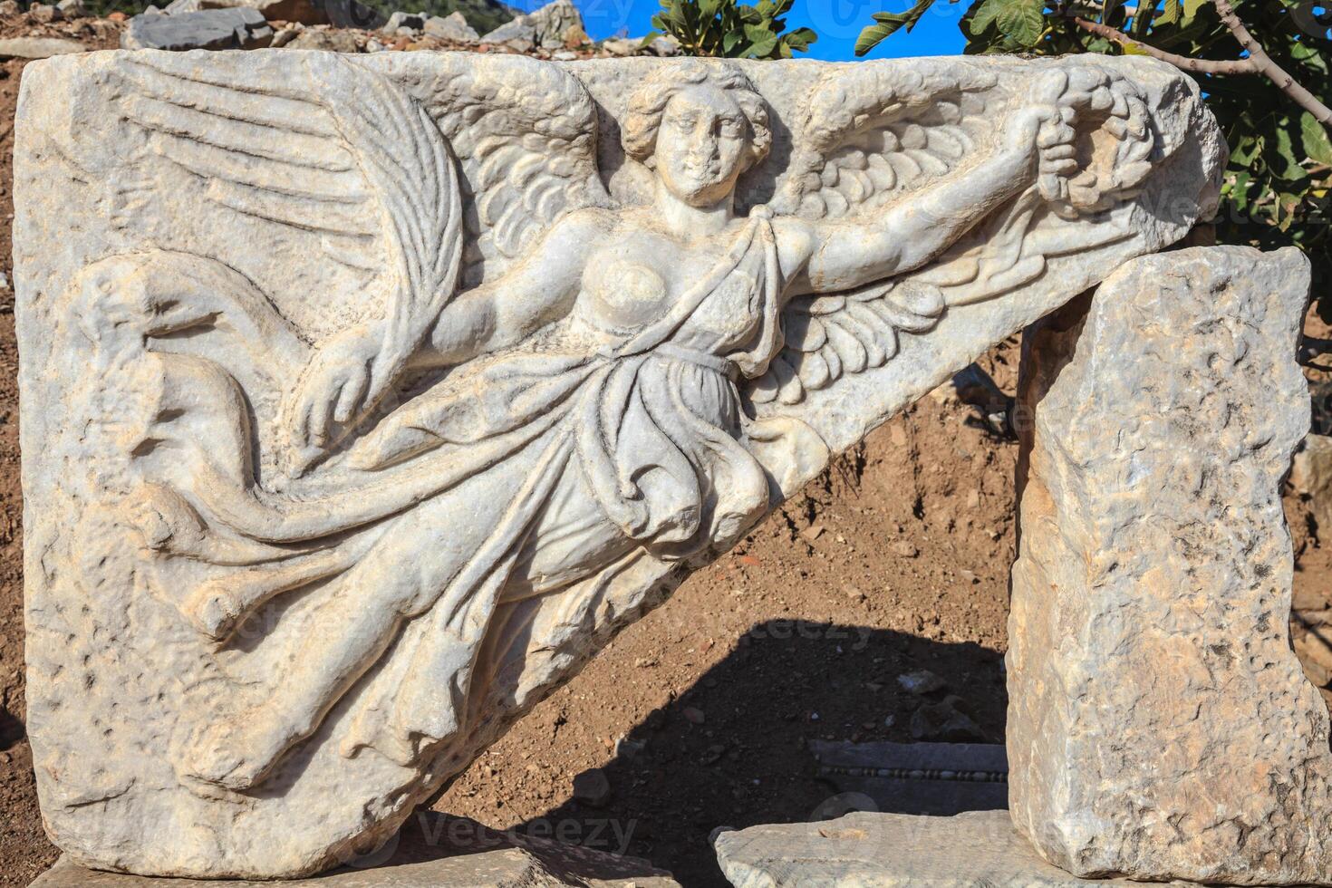 Bas relief, marble stone carving of the goddess Nike at Curetes street in the ruins of ancient city of Ephesus, Turkey. photo