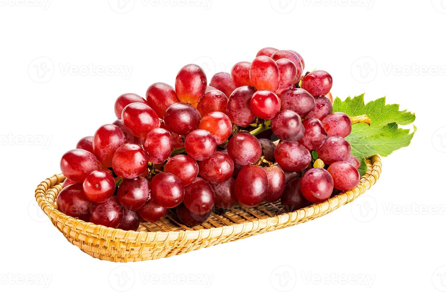 Bunch of ripe red grapes, Crimson Seedless Grapes,  with green leaf in bamboo tray isolated on white background with clipping path. photo