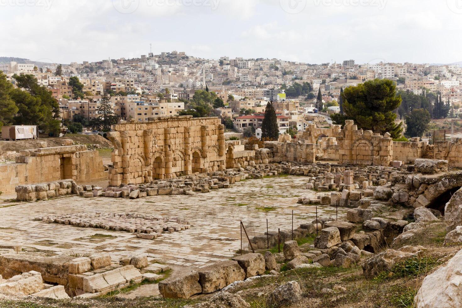 ver de el restos antiguo romano ciudad de jerash en Jordán con el moderno ciudad en el antecedentes. foto