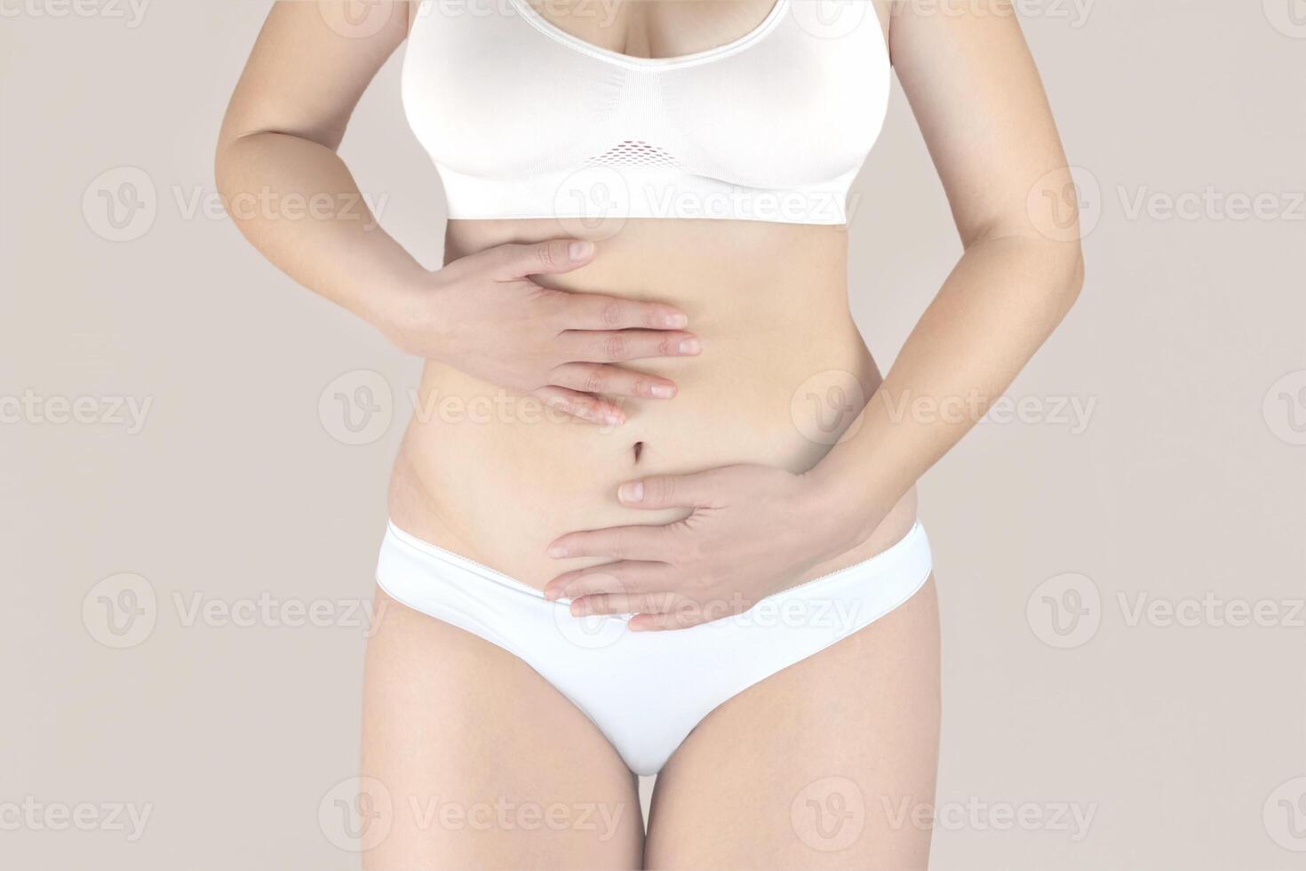 mujer en blanco ropa interior con menstrual dolor es participación su dolor barriga, mujer con abdominal dolor y estómago obstáculo foto