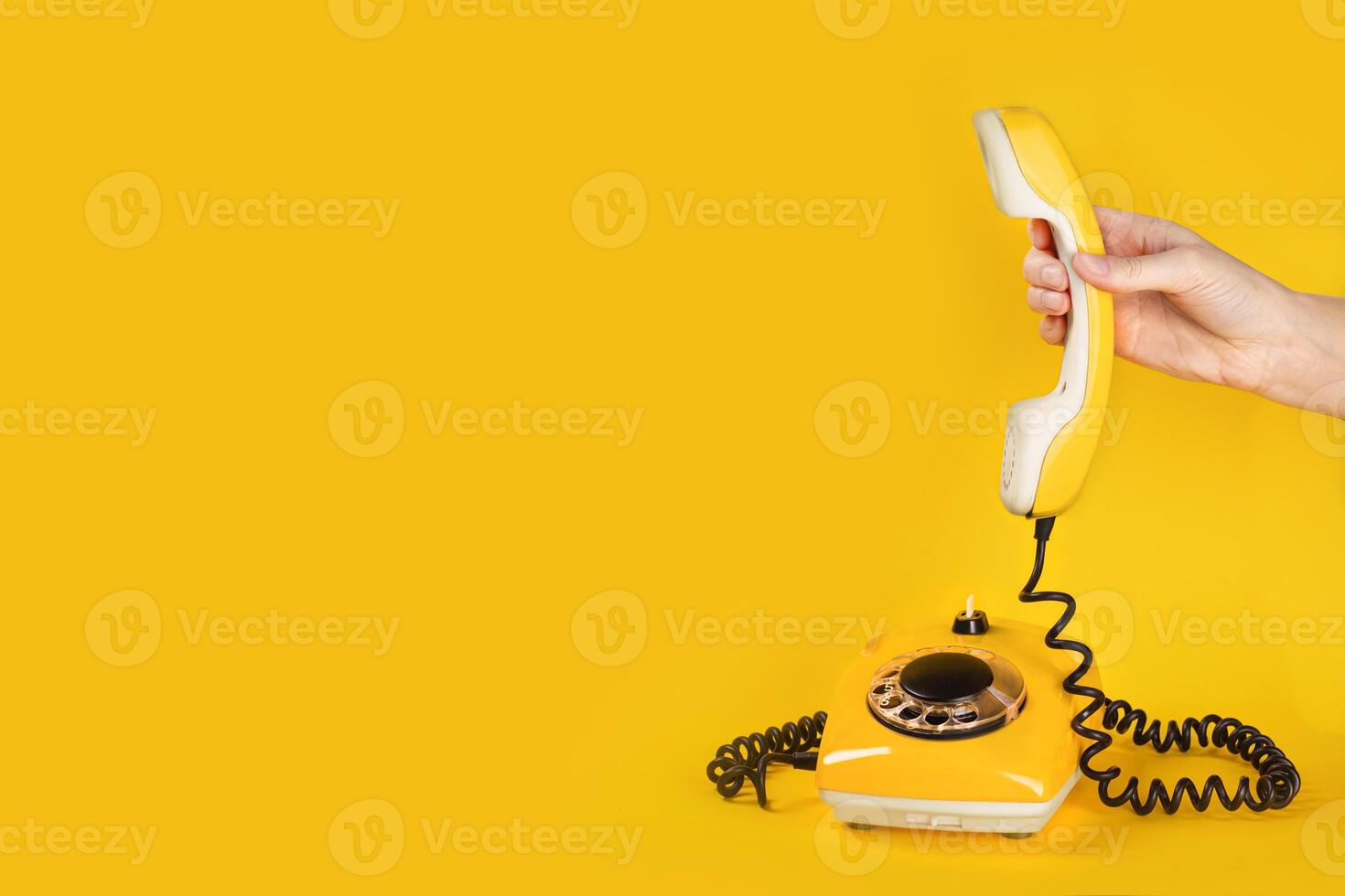 Banner with old yellow phone, hand picks up the phone on yellow background flat lay copy space photo